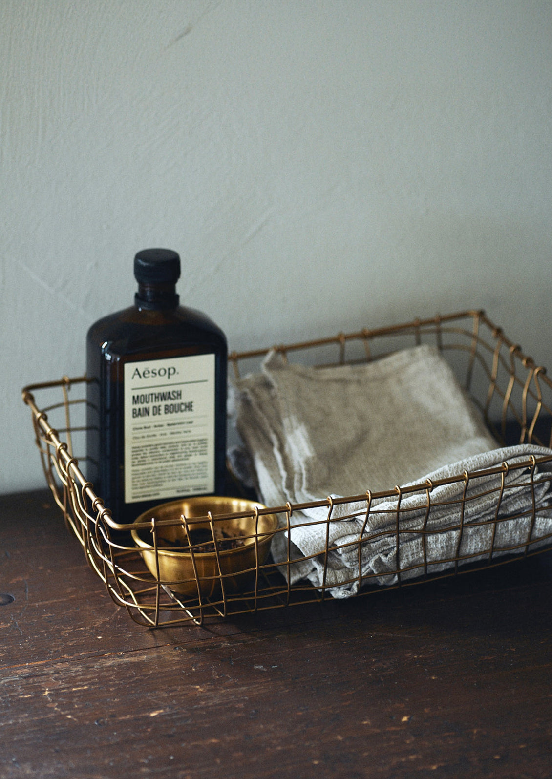 A shallow, rectangular basket made from brass wire.
