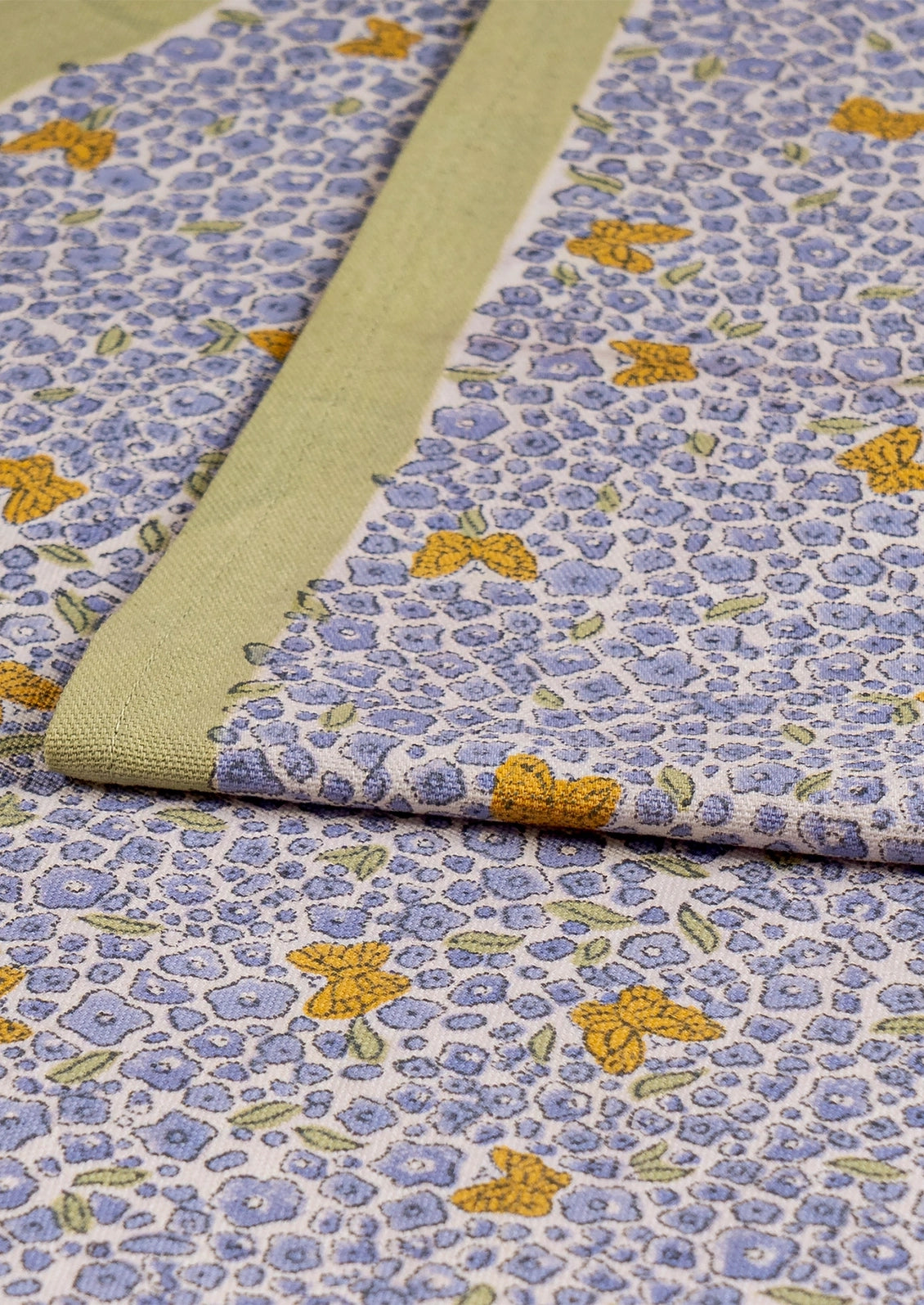 A table runner with lavender floral print and orange butterflies with sage green border.