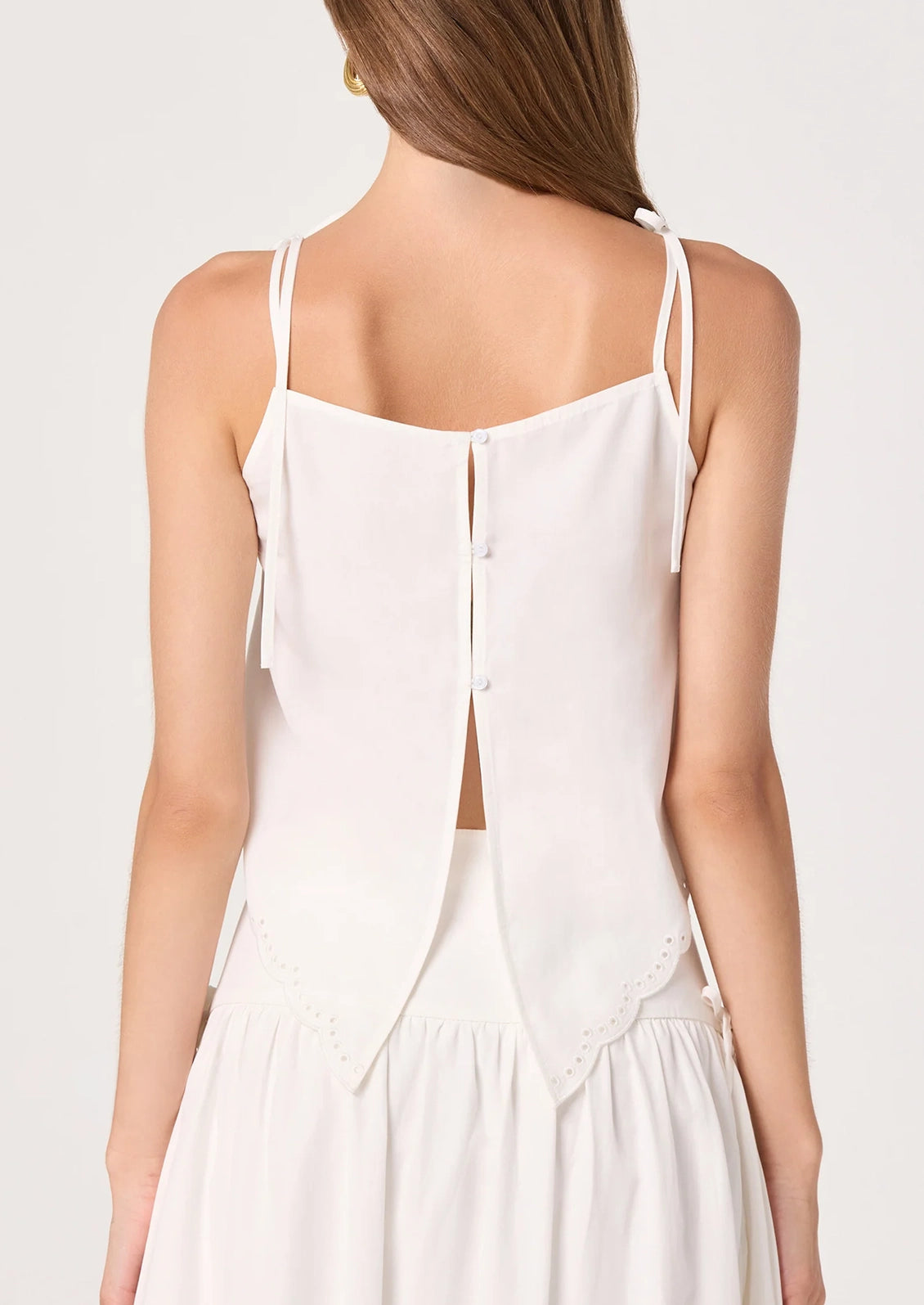 White lace top worn by a person on a plain background
