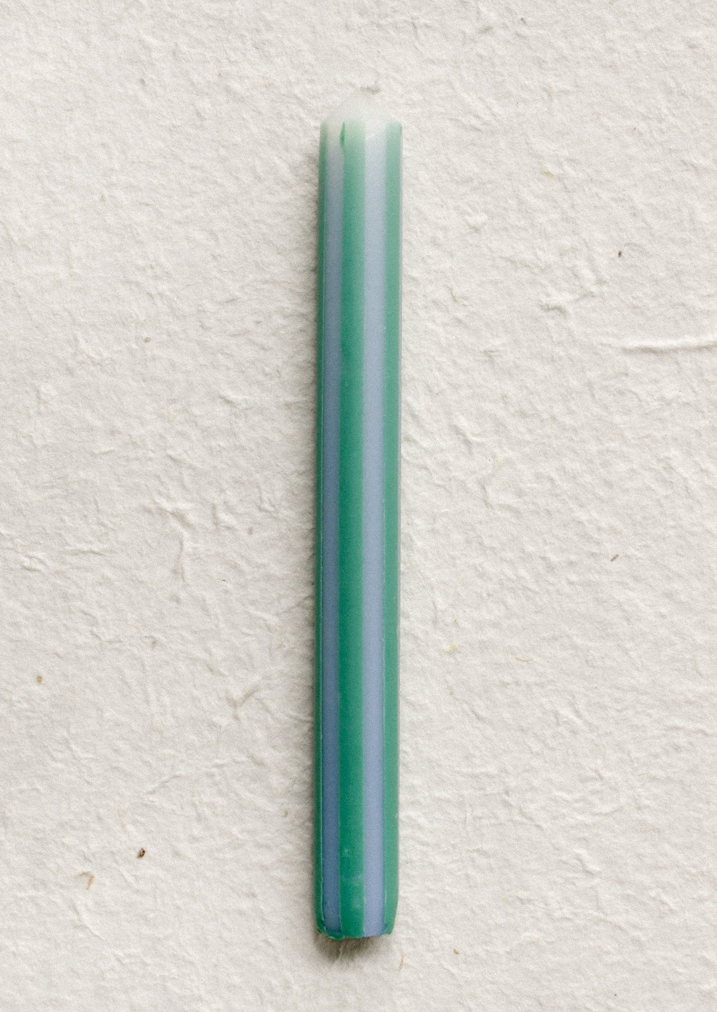 A pinstripe patterned candle in periwinkle and aqua.
