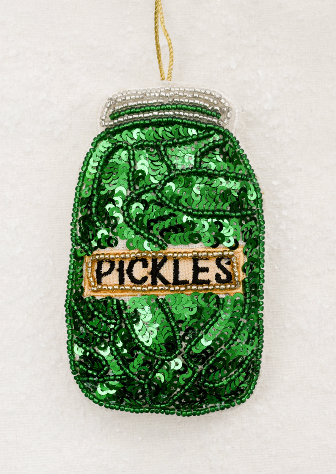 Green sequin jar ornament with 'PICKLES' label.
