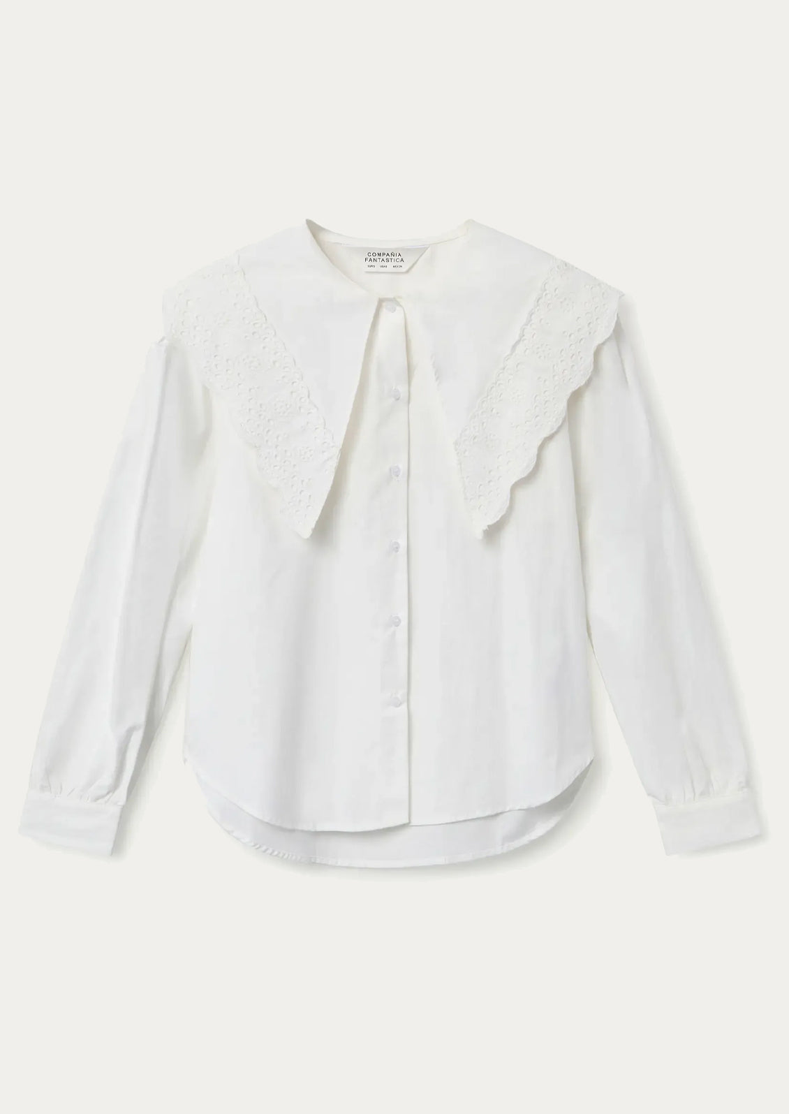 White blouse with intricate collar design worn by a person.