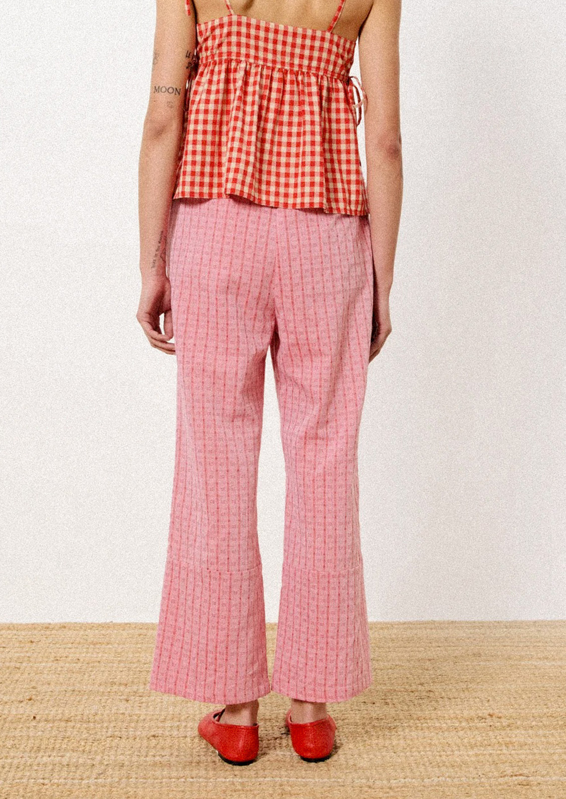 A pair of pants in red jacquard check pattern.