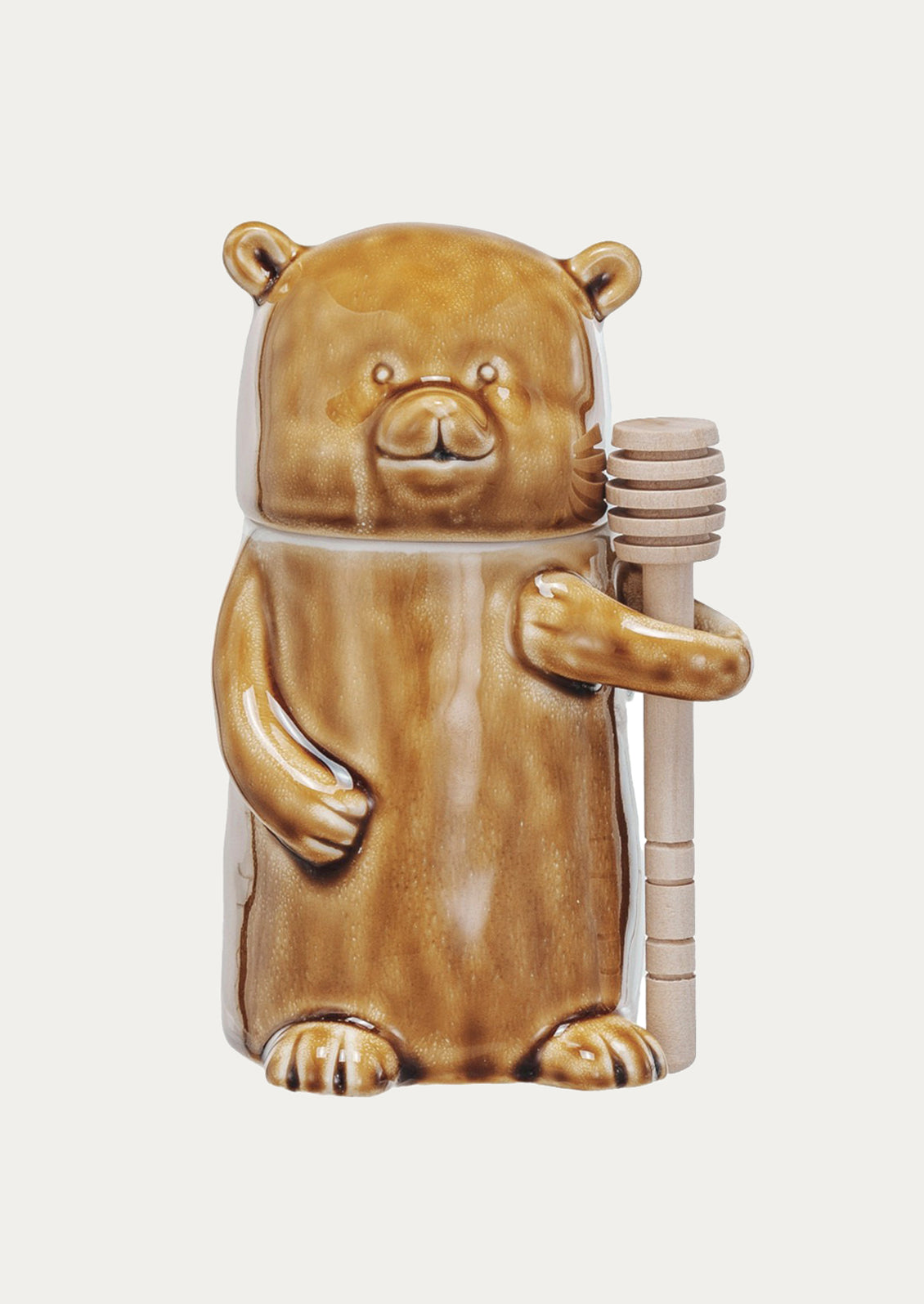 Bear-shaped container holding honey on a white background