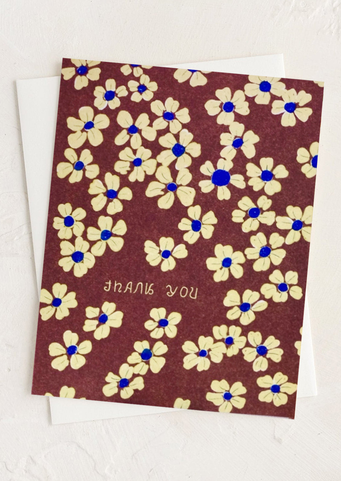 A brown greeting card with yellow flowers and "Thank you" text.
