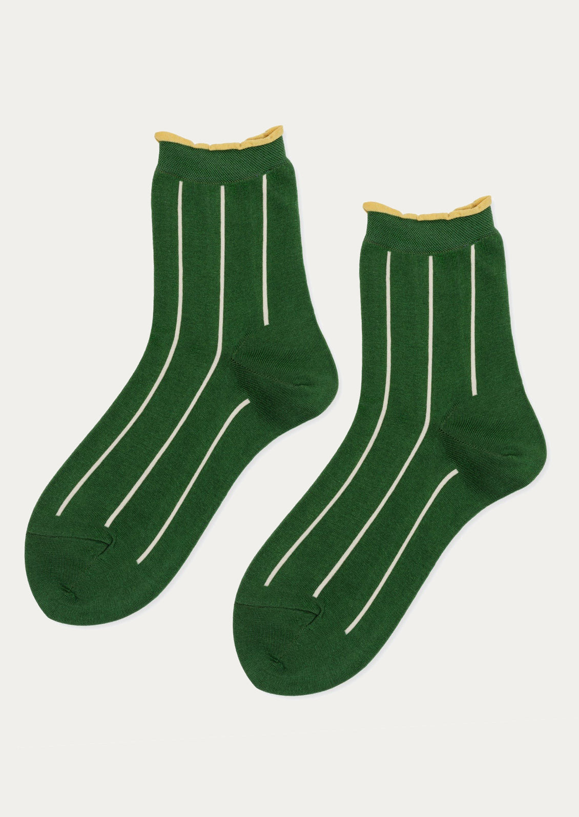 A pair of green socks with vertical white stripes and yellow trim at ankle.