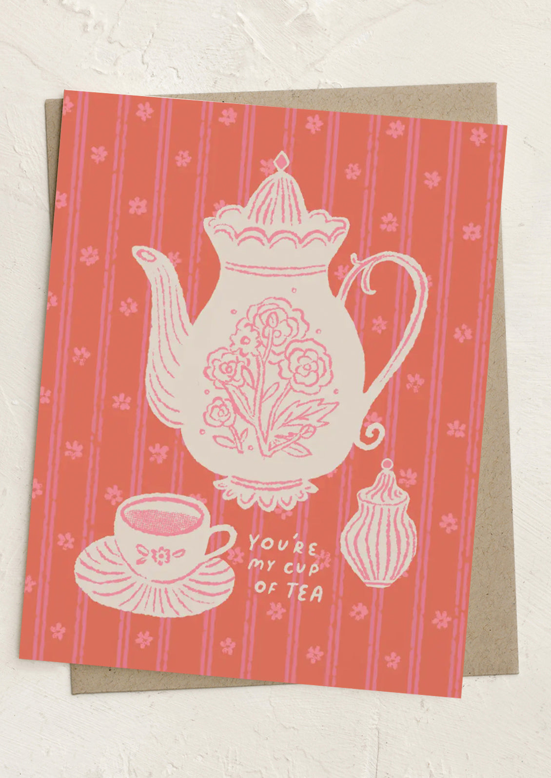 Greeting card with a teapot design and text on a striped background