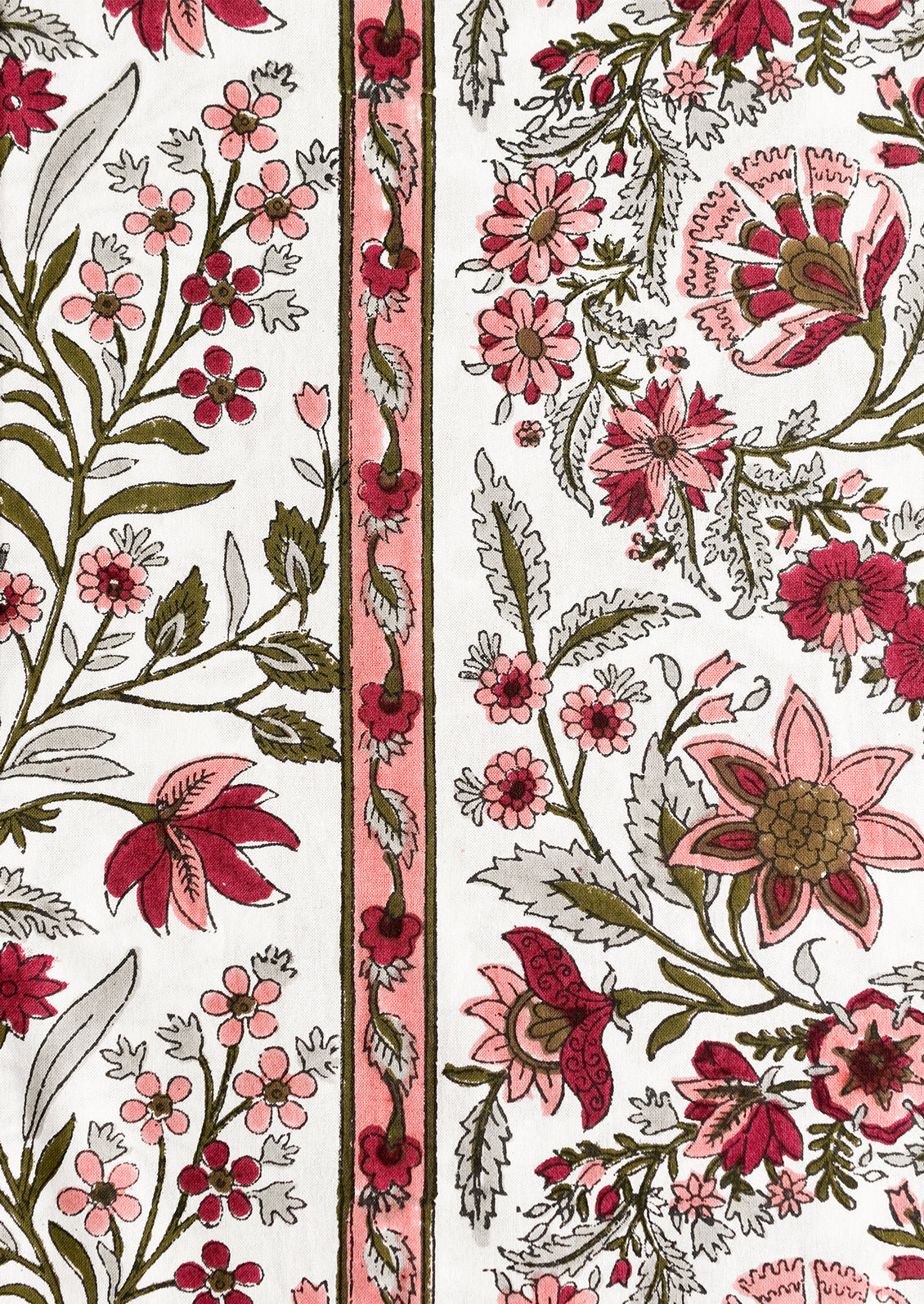 A block printed, floral patterned tablecloth in shades of pink and sage green.