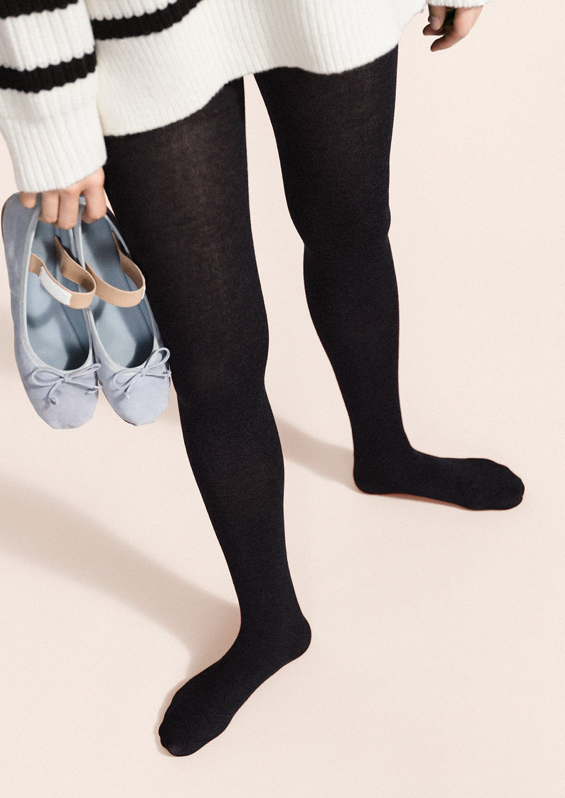 A person wearing knit tights in navy.
