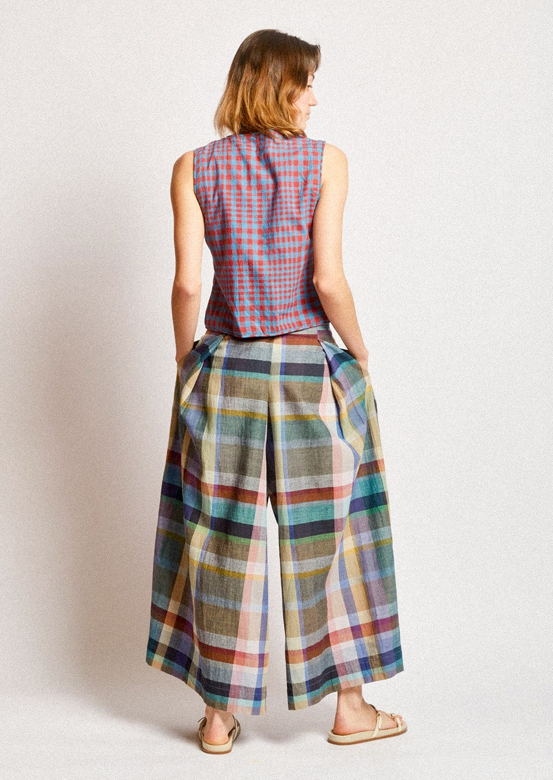 A woman wearing a pair of colorful multicolor check print wide leg pants.