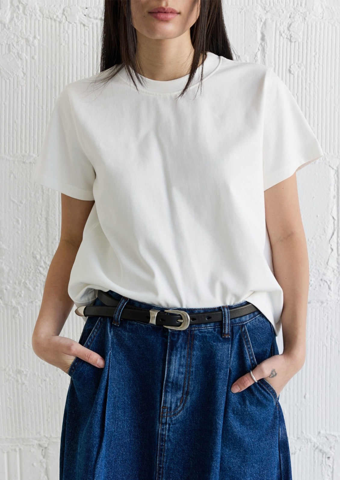 A woman wearing a white t-shirt and white pants.