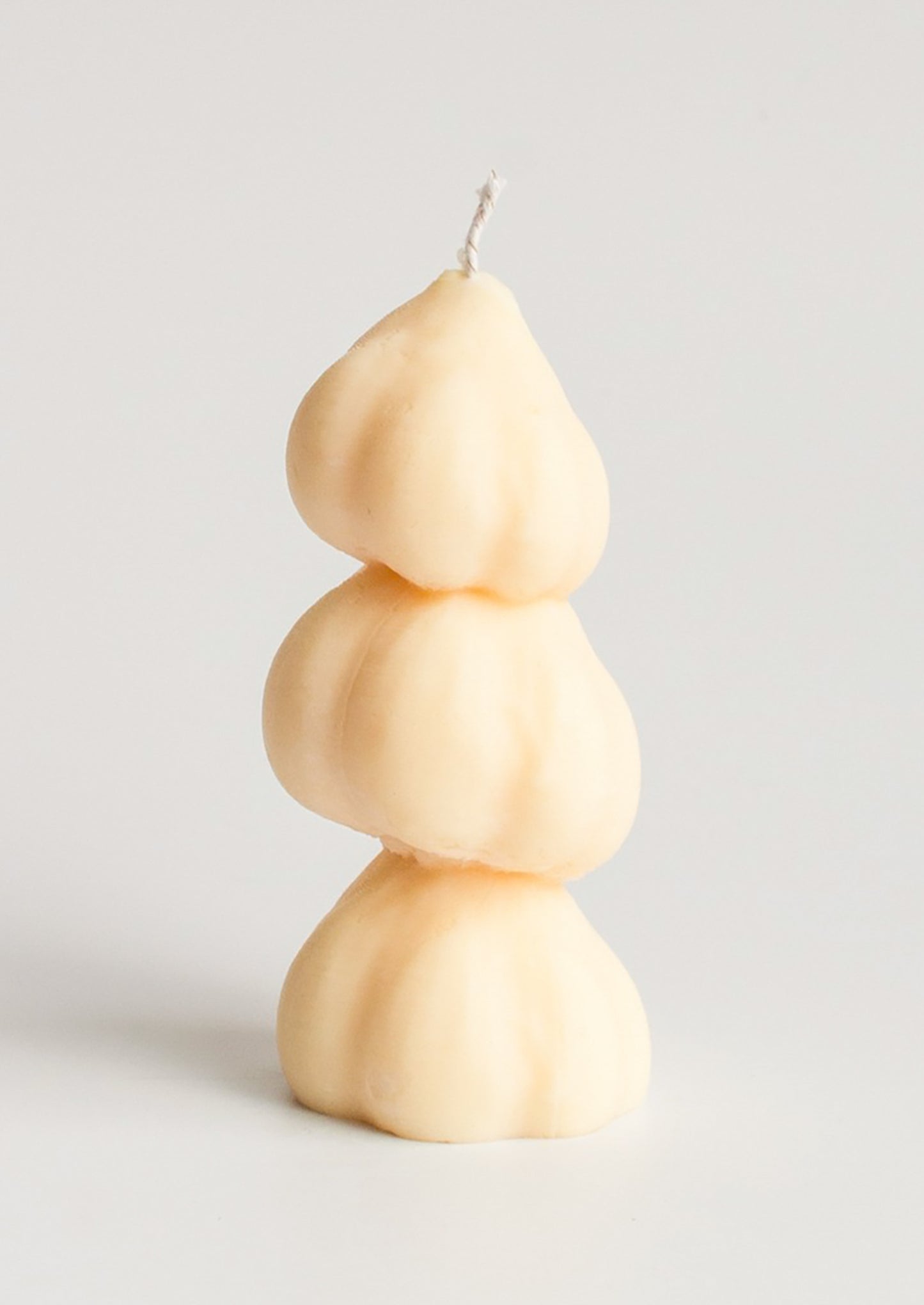 A candle in the shape of three stacked garlic bulbs.