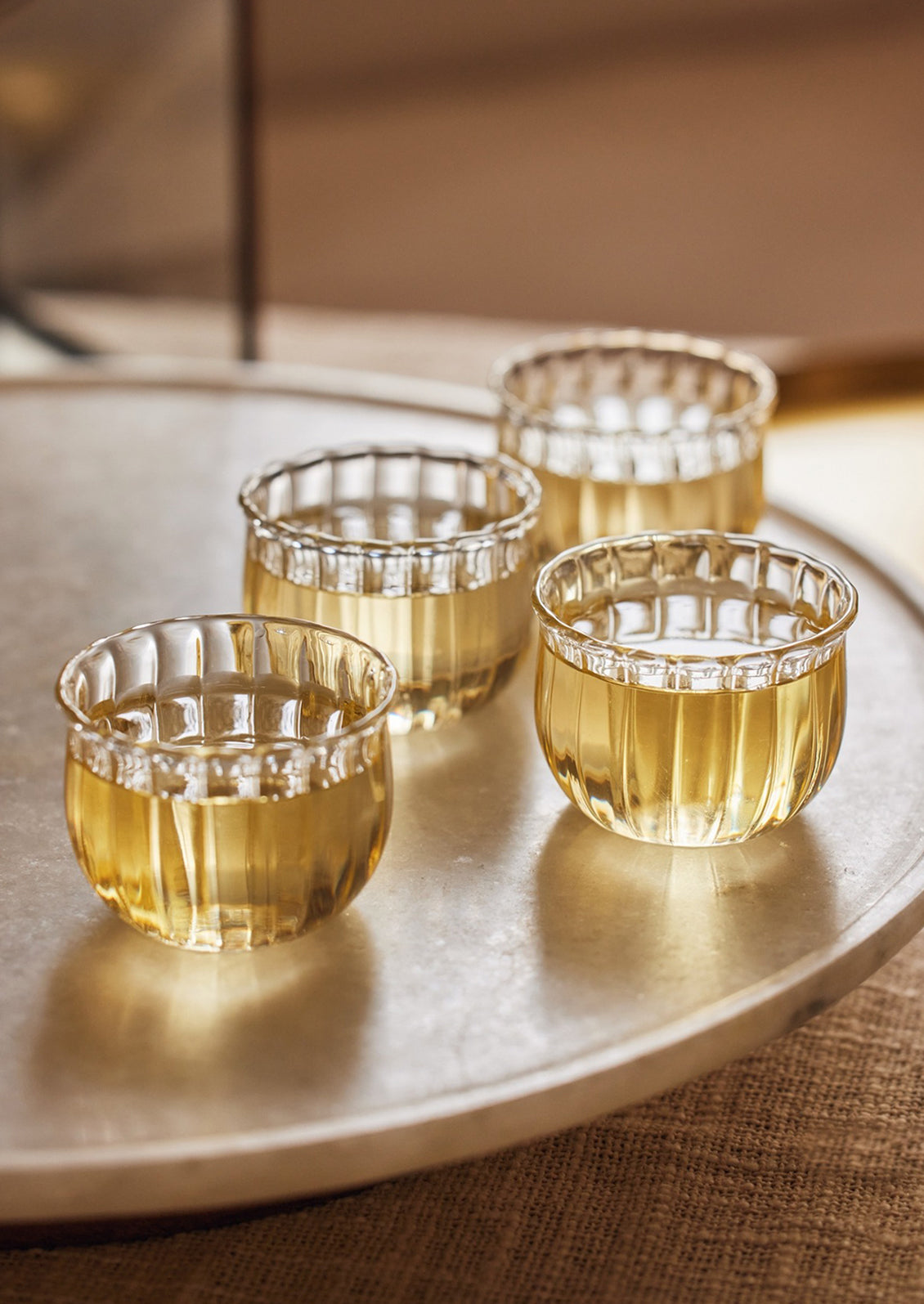 Small glass wine cups with fluted texture.