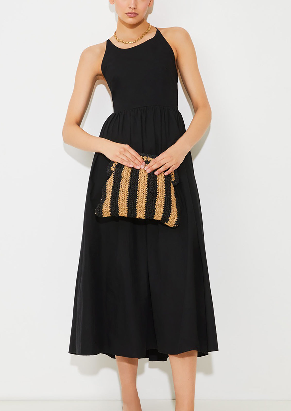 A woman wearing a black dress with X-open back.