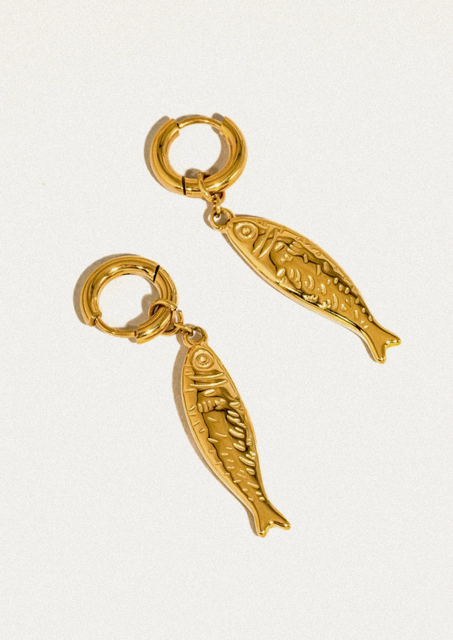 A pair of gold fish earrings.