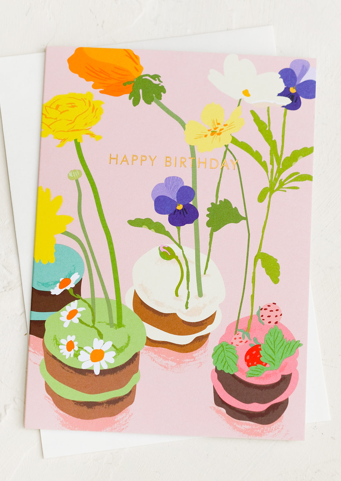 A birthday card with illustration of floral decorated cakes.