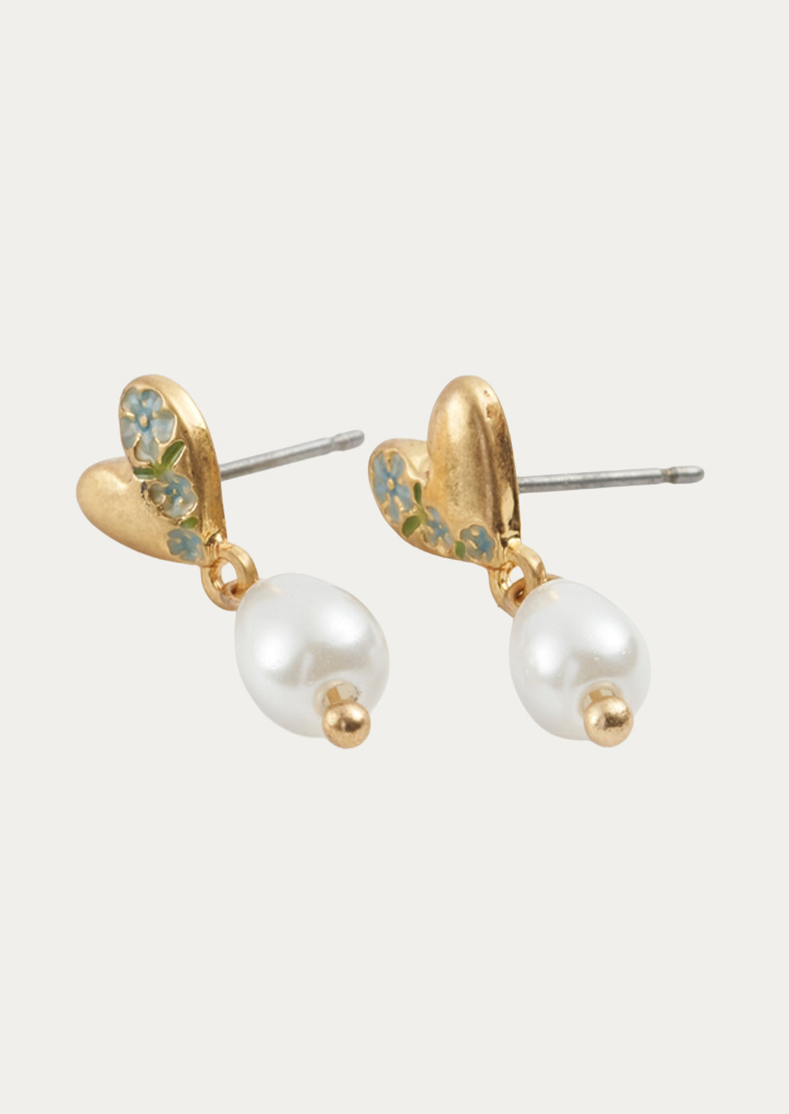 A pair of gold heart shaped earrings with a dangling pearl.