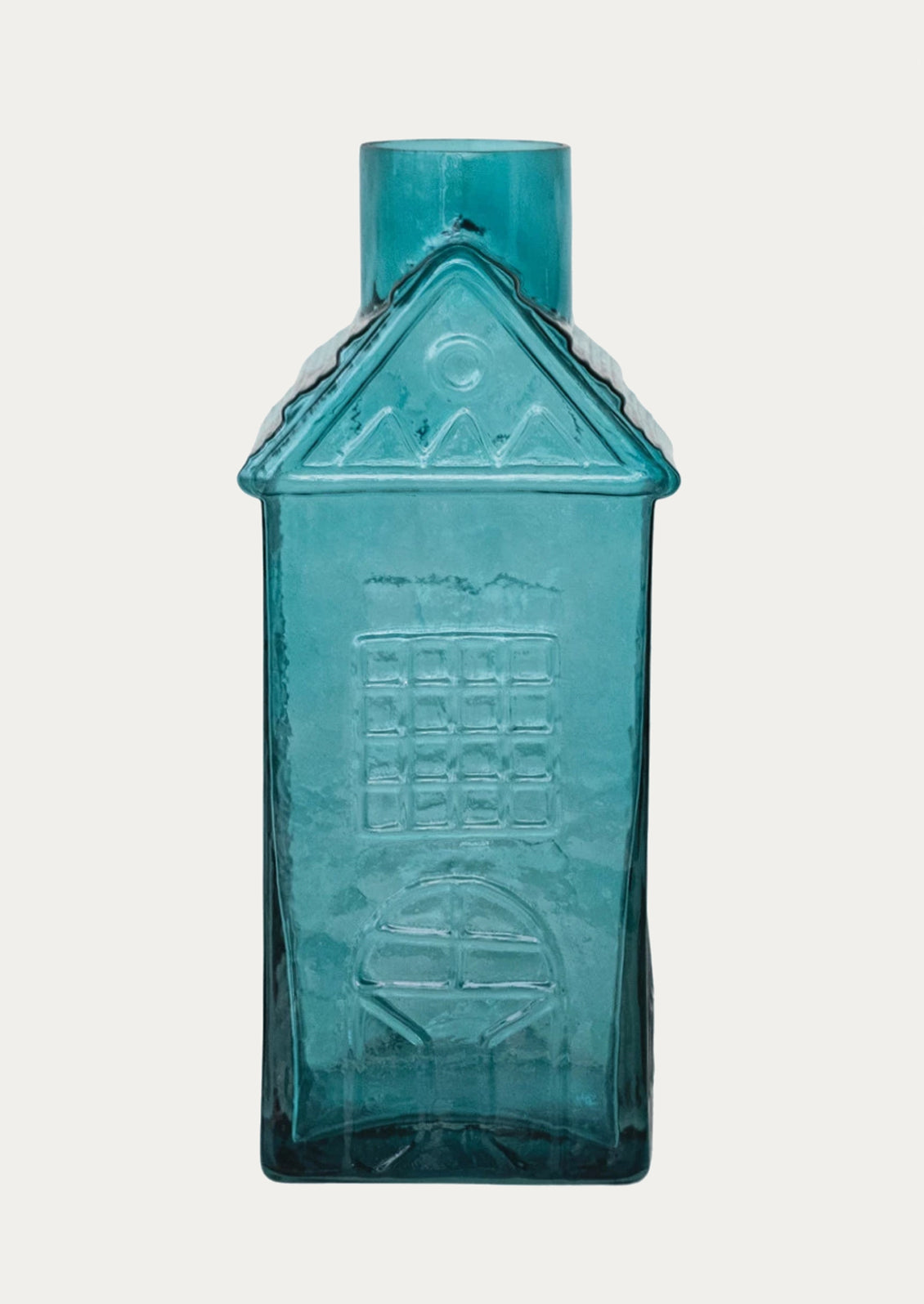 A glass vase in the shape of a house in green.