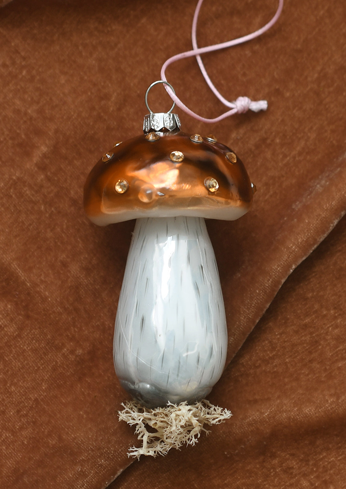 A glass ornament resembling a button mushroom with crystal detail.