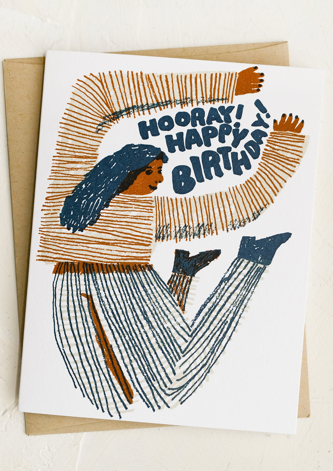 A birthday card with illustration of woman jumping, text reads "Hooray! Happy Birthday!".