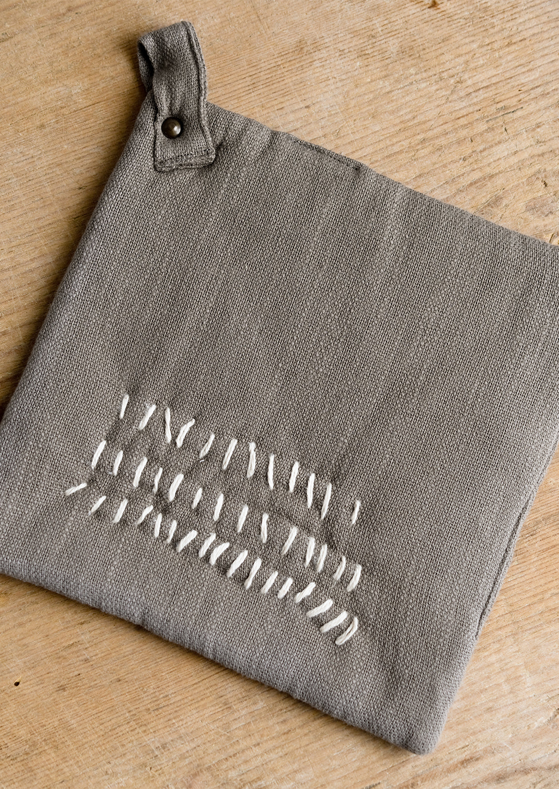 A cotton holder in taupe with decorative contrast stitching in ivory.
