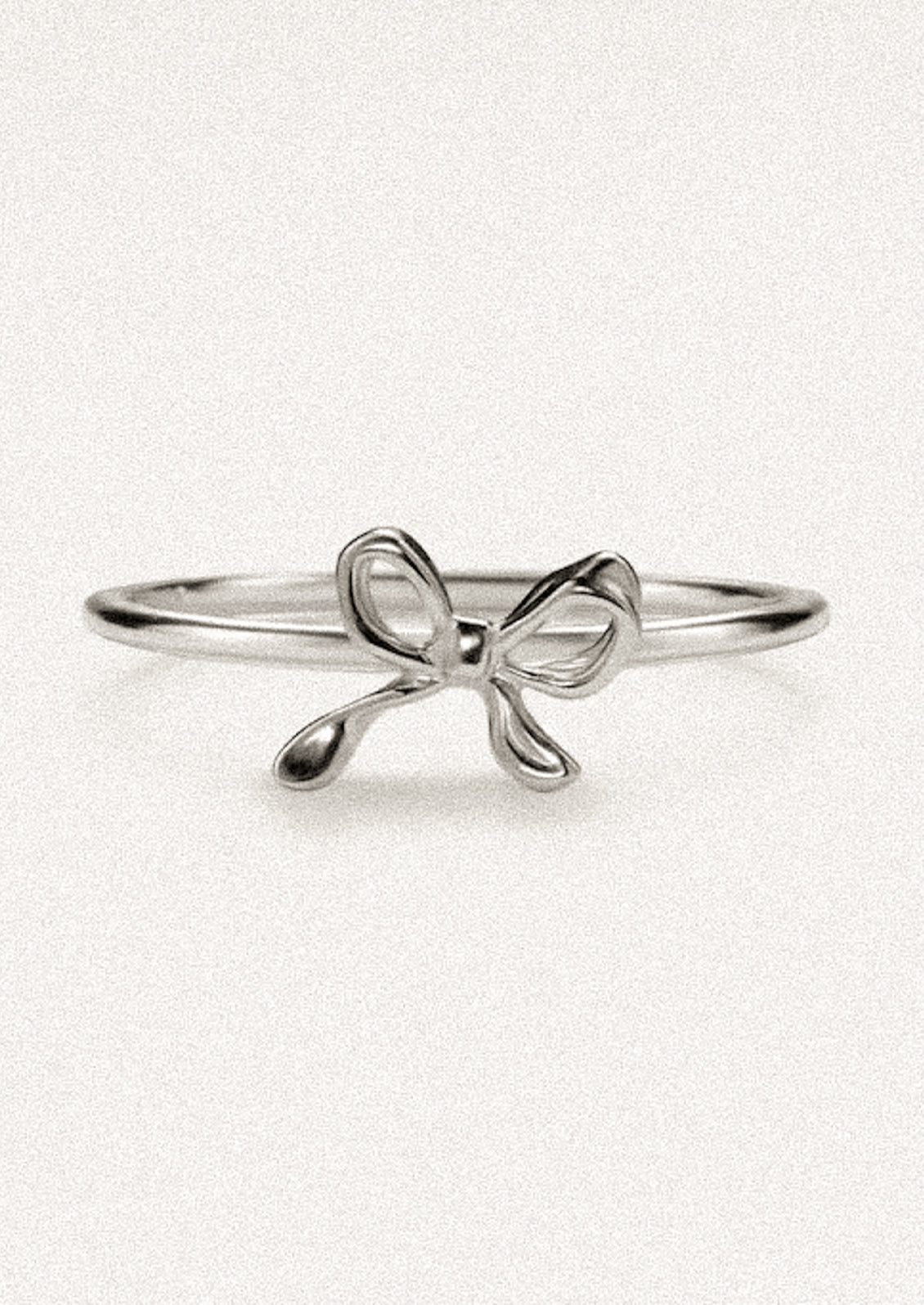 A silver ring with small bow shape.