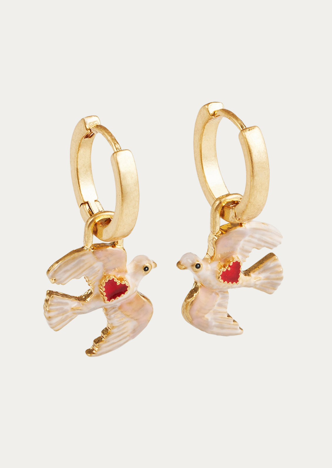 A pair of gold hoop earrings with dove charms adorned with a red heart.