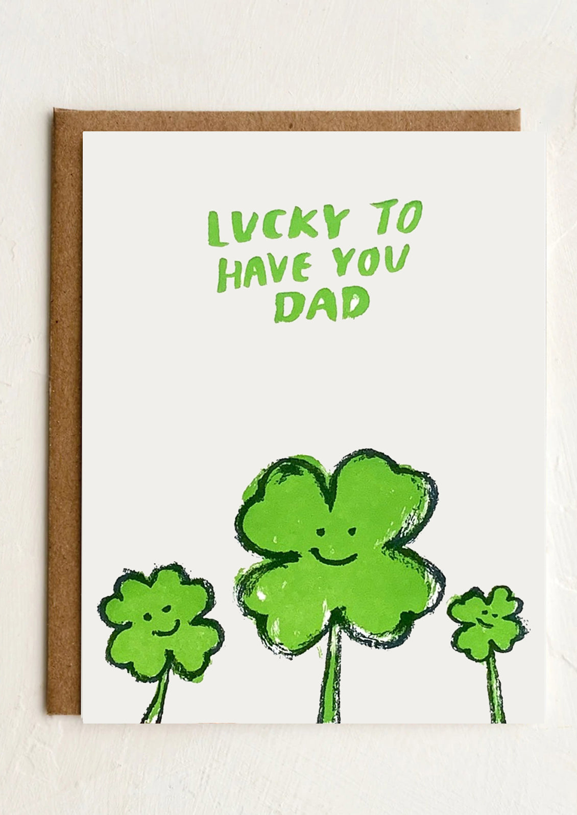 A greeting card with images of four leaf clovers, text reads "Lucky to have you Dad".