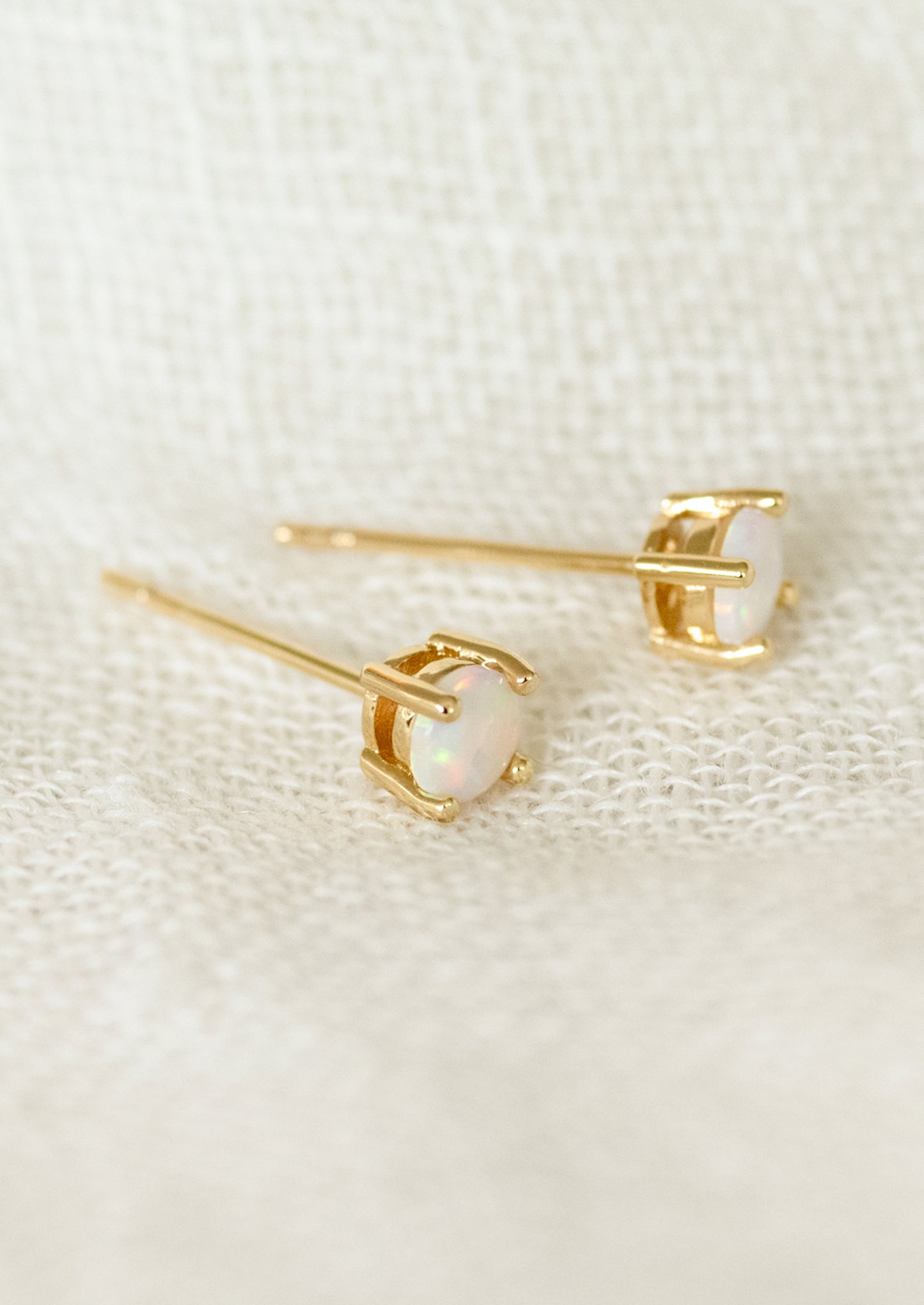 A pair of minimal stud earrings with opal stones.