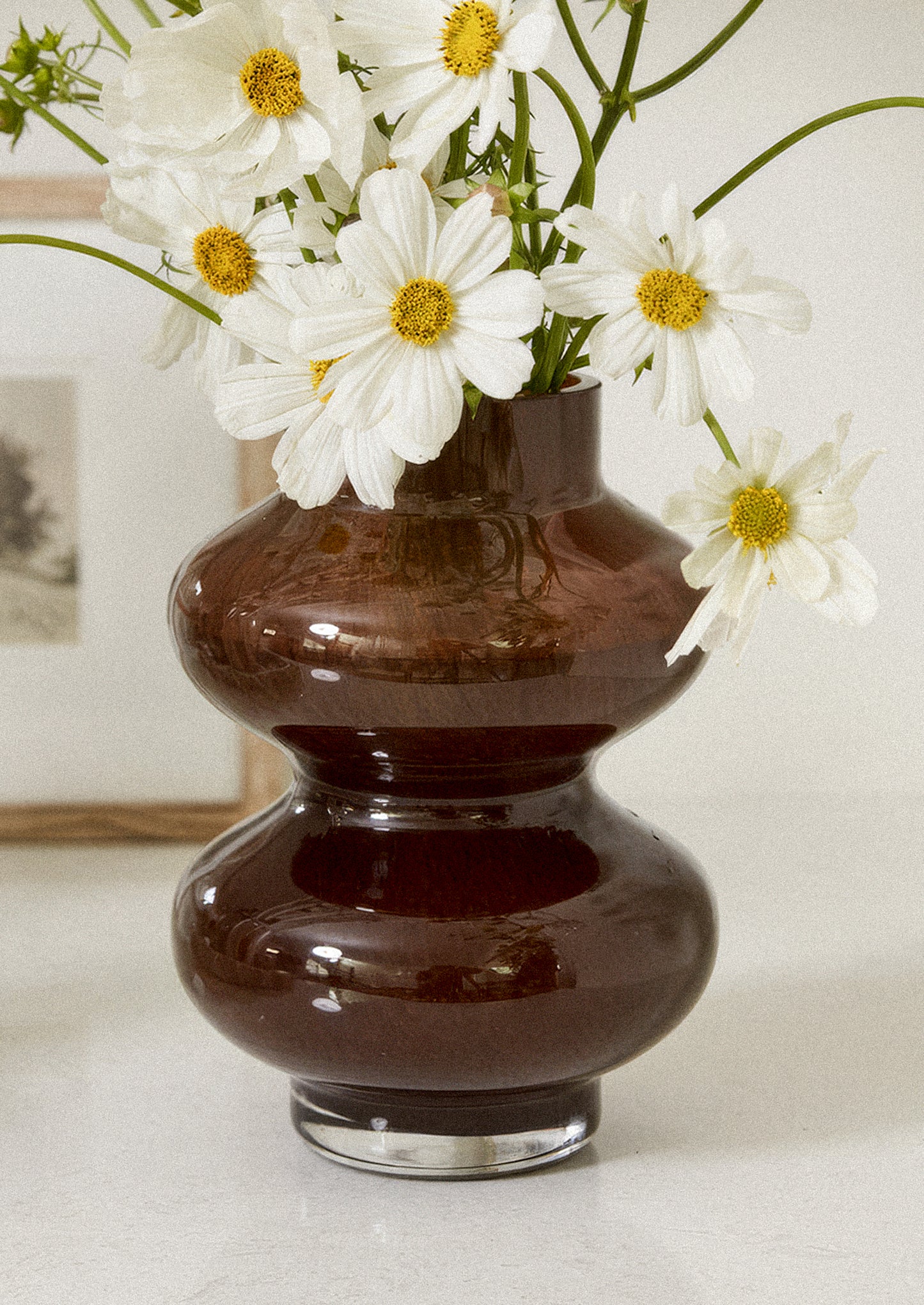 A brown glass vase with hourglass shape.