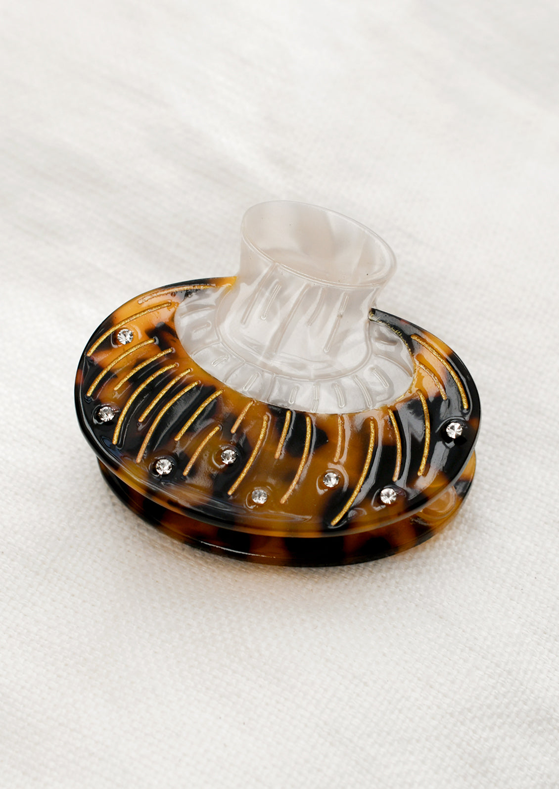 A hair claw in the shape of a brown mushroom with crystal detailing.