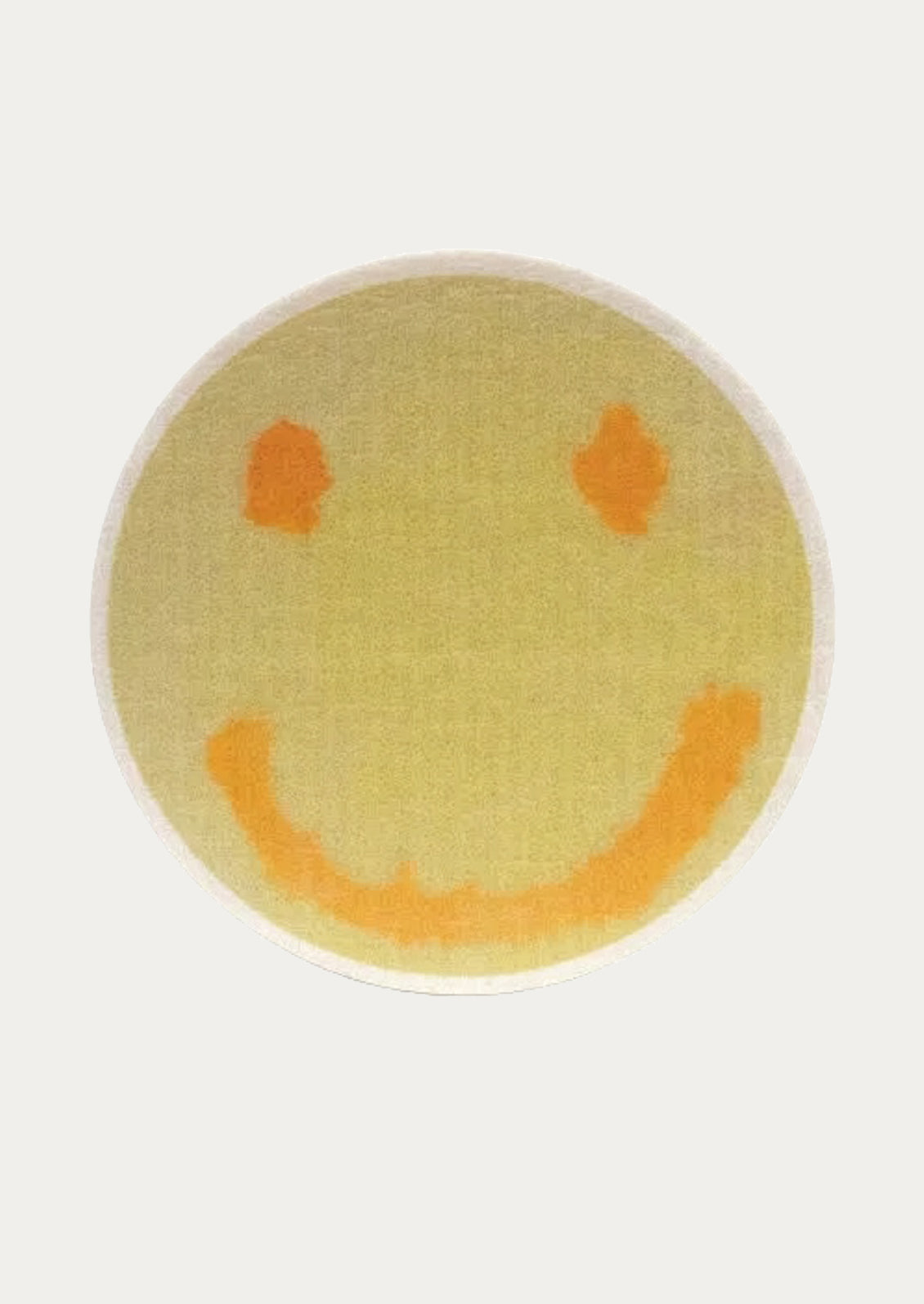 Round yellow sponge with smiley face design on a white background