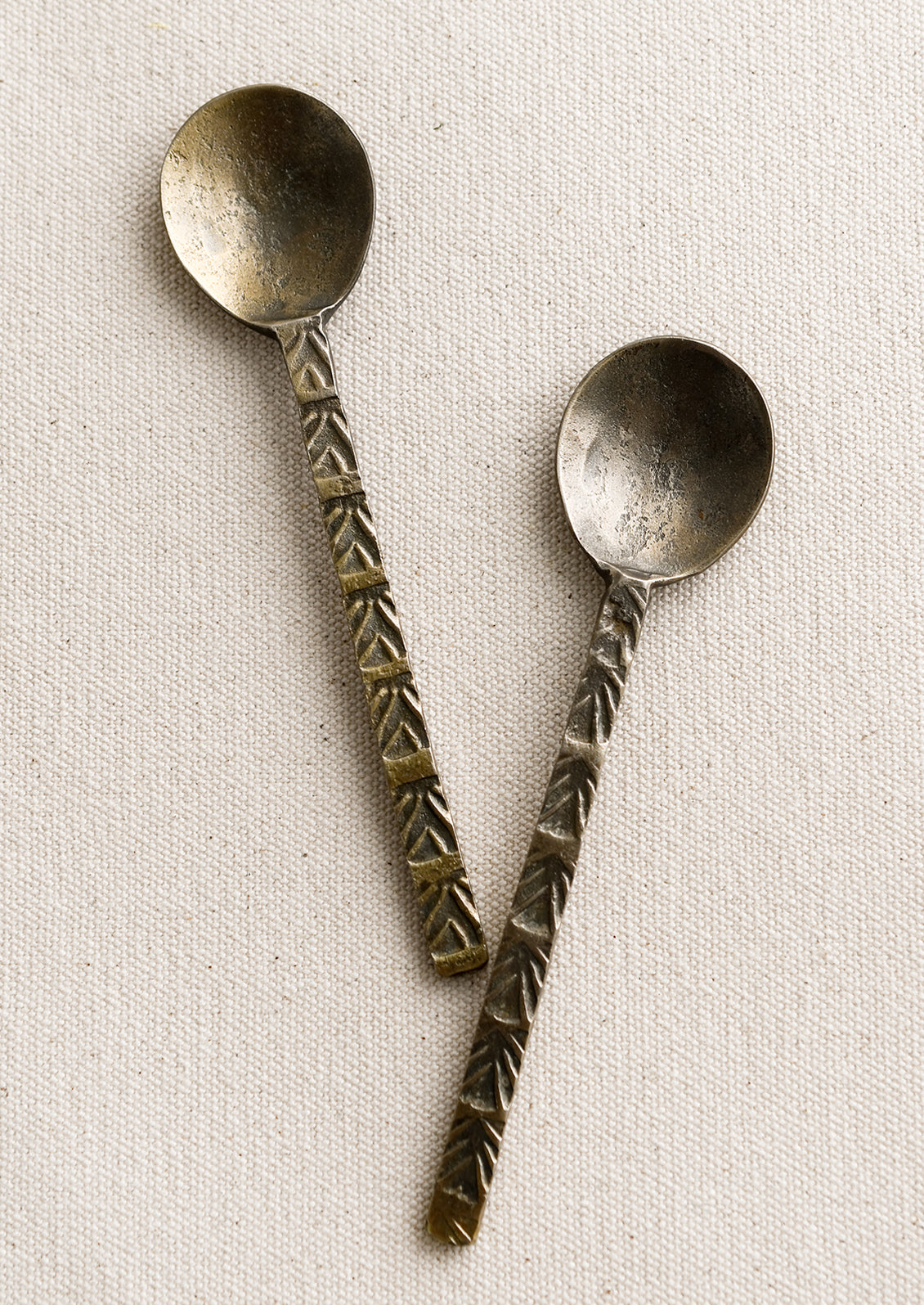 A brass spoon with textured handle.
