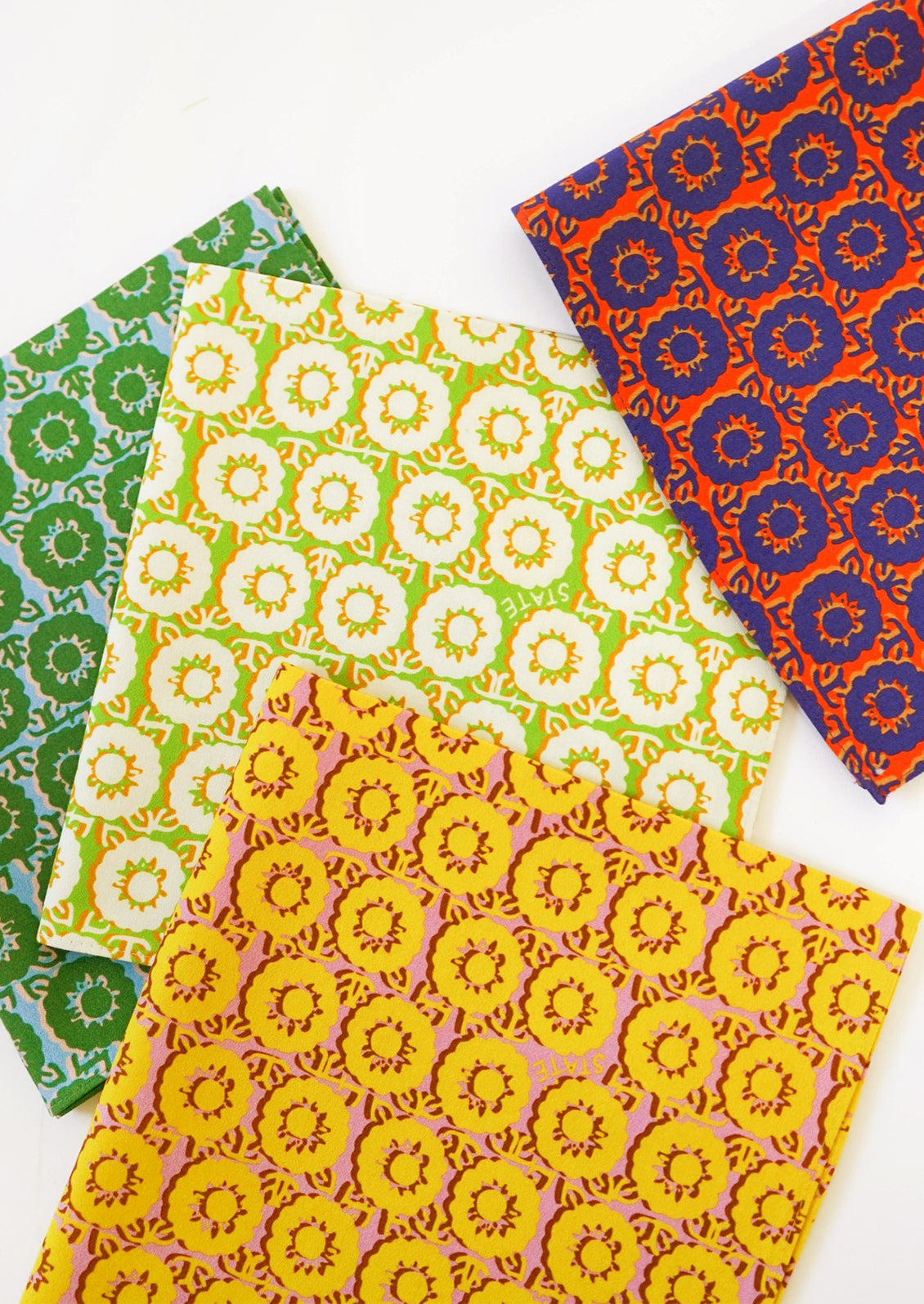 A set of four different brightly colored napkins in floral pattern.