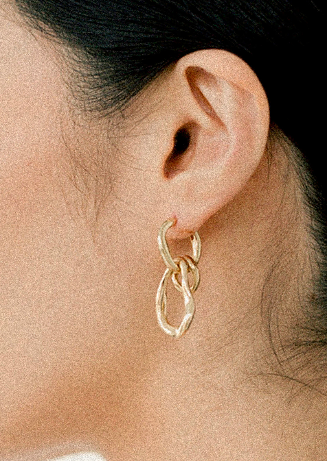 A pair of unique gold hoops earrings.