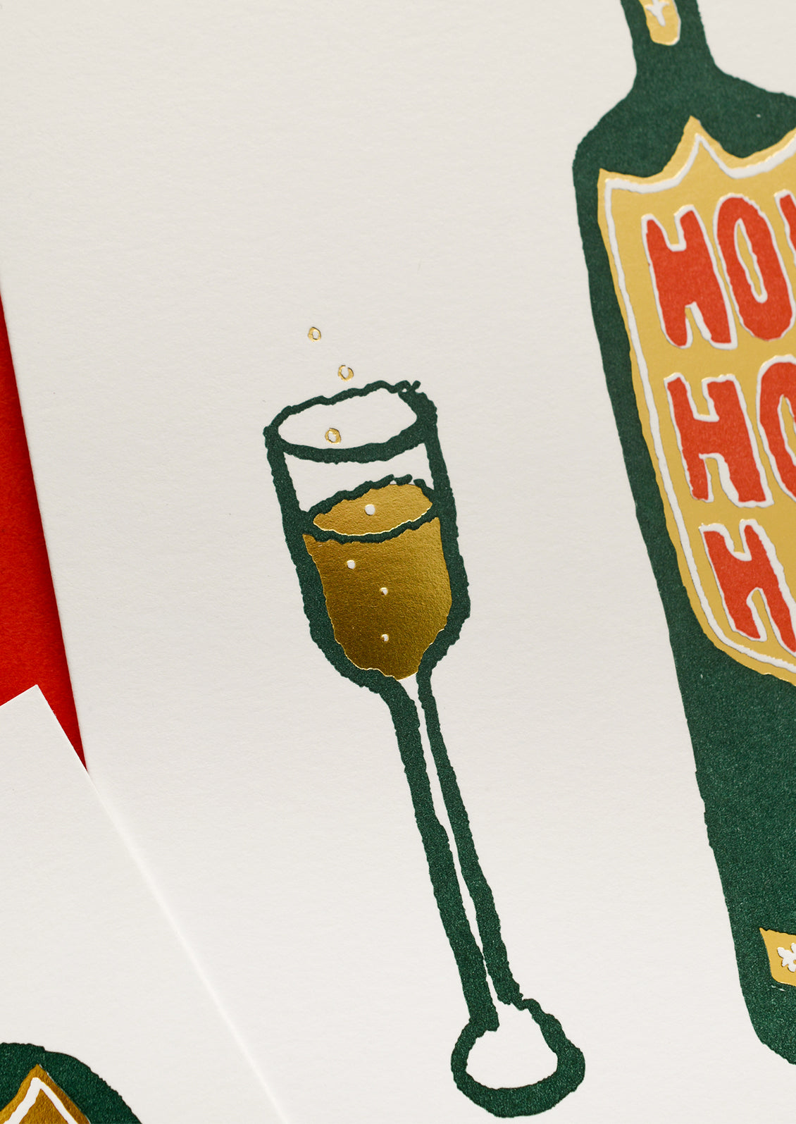 A greeting card with illustration of glass of champange next to bottle, text on bottle reads "Ho Ho Ho!".