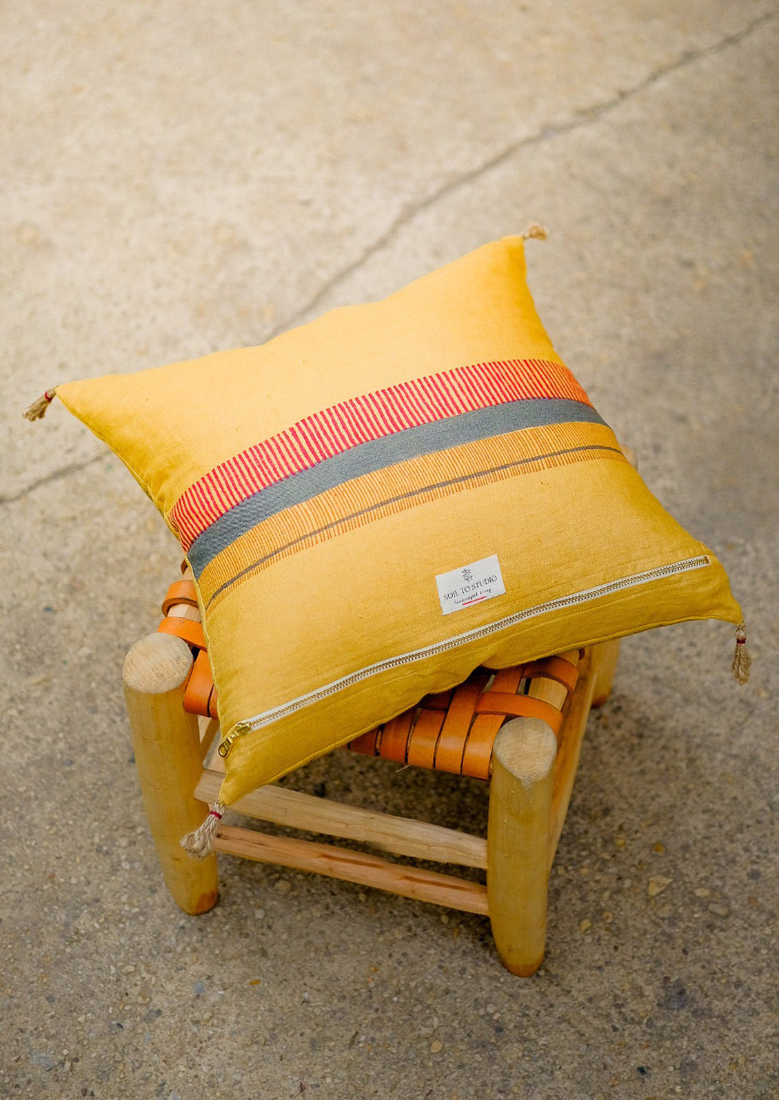 The back of the pillow with decorative stripe detailing and zip closure.
