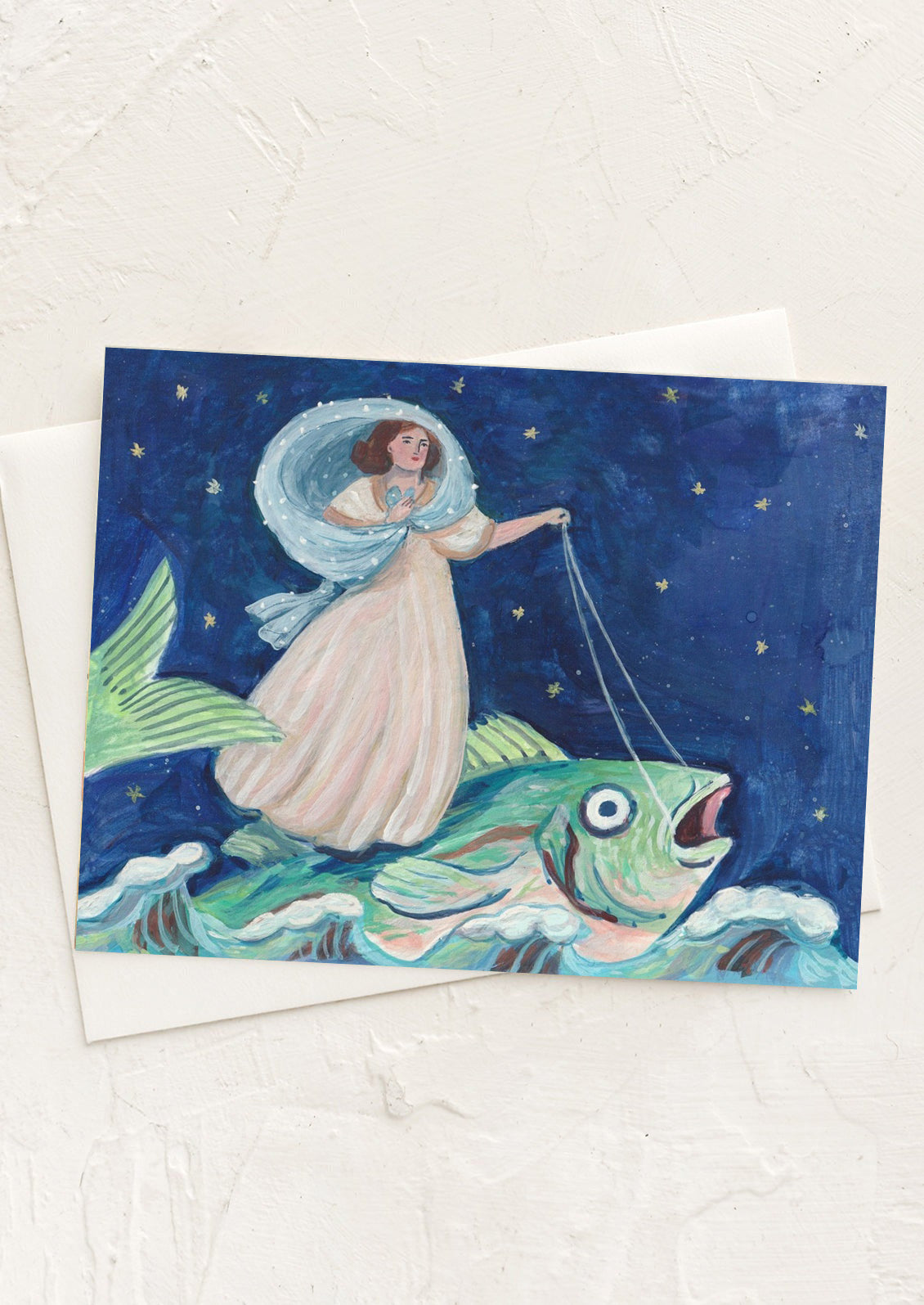 A card with fantastical illustration of woman riding a fish.