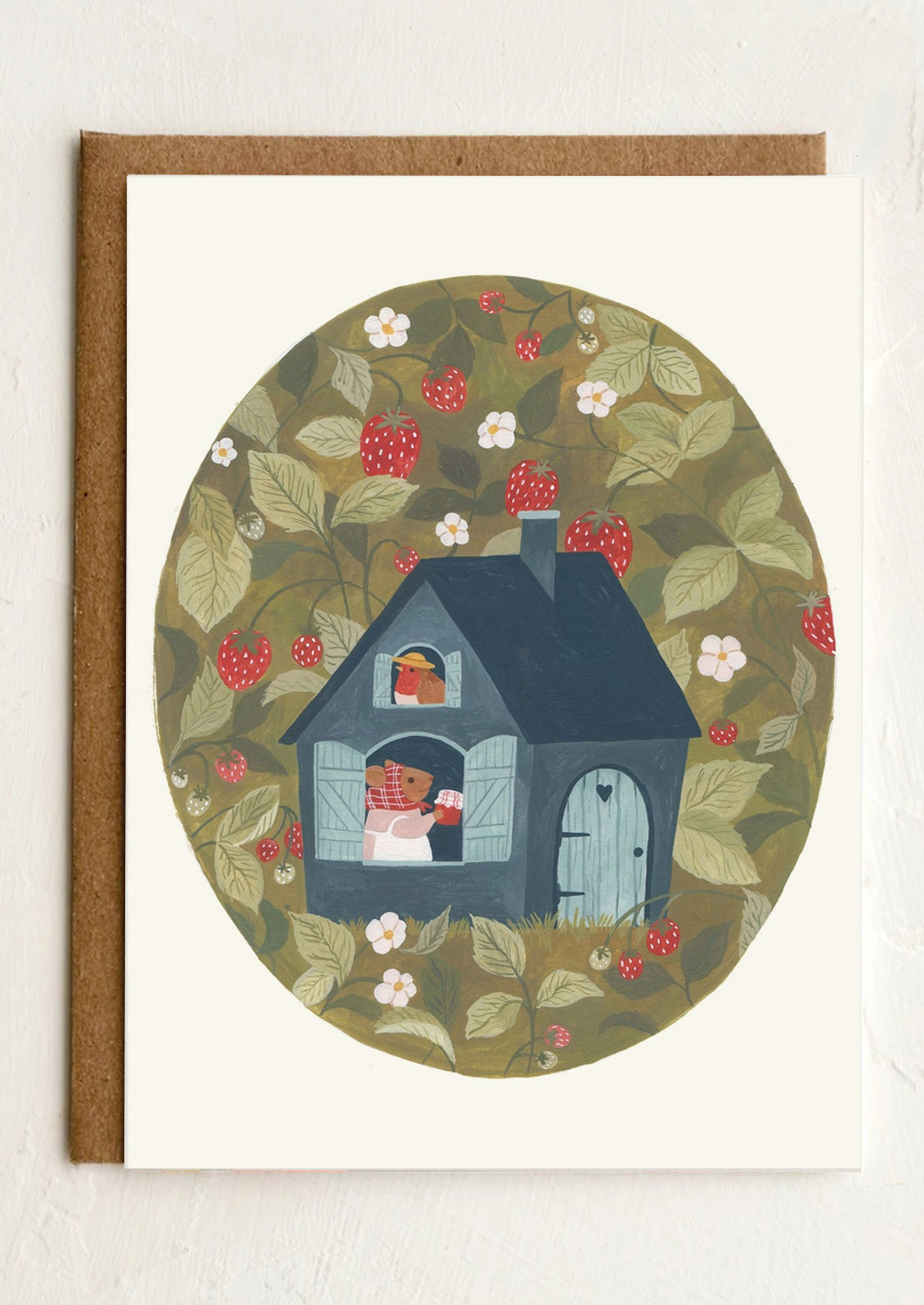 A greeting card with illustration of a small blue house amidst strawberries.