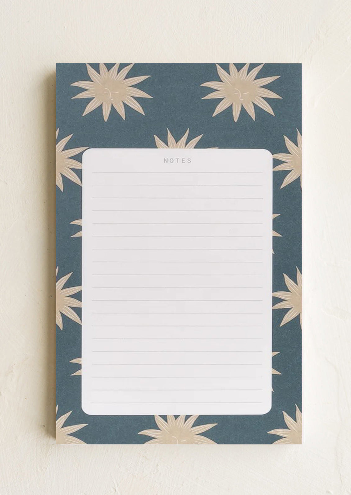 A ruled notepad with patterned background border in suns print.