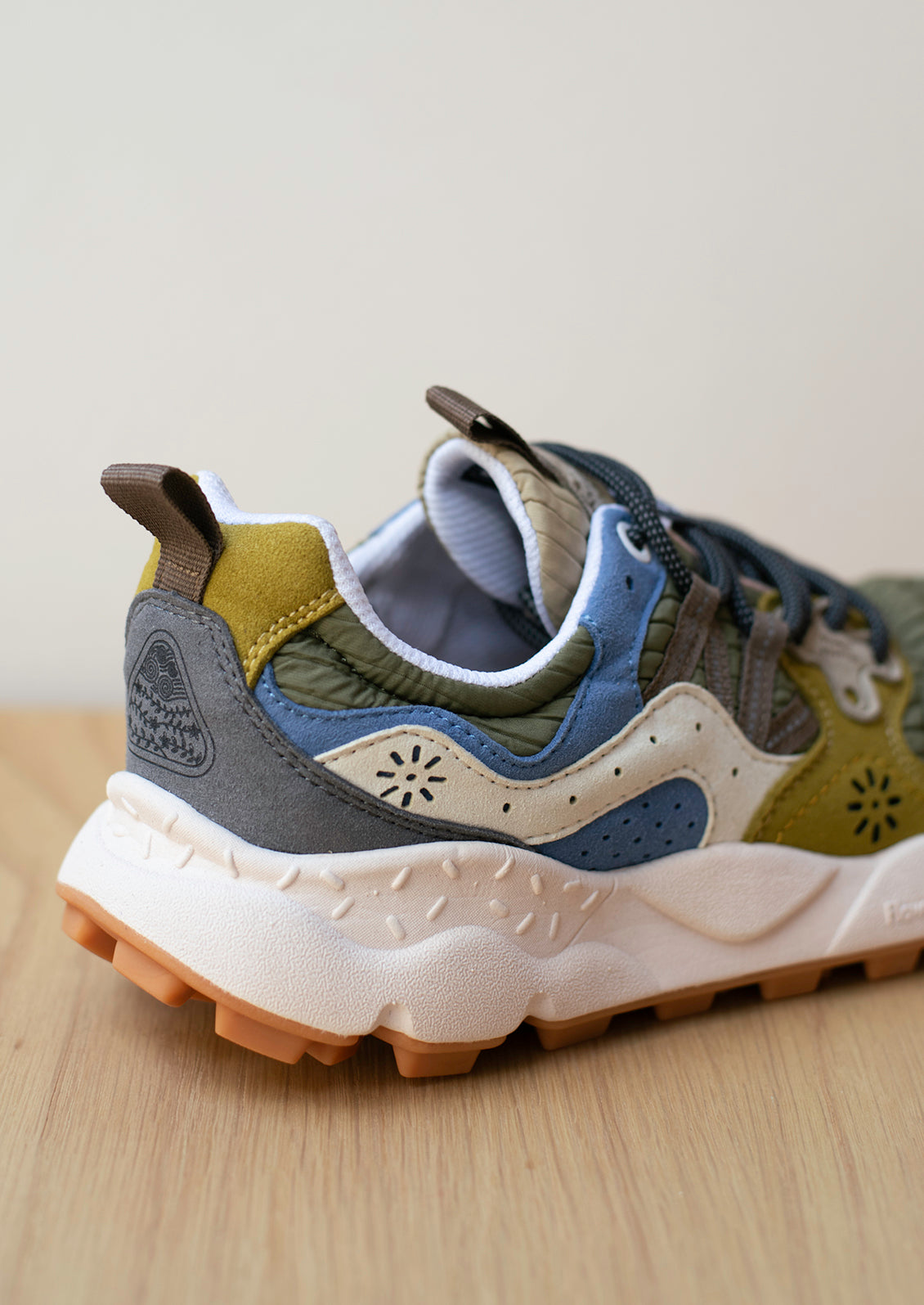 A pair of sneakers in ribbed nylon and suede, green and mustard color palette.