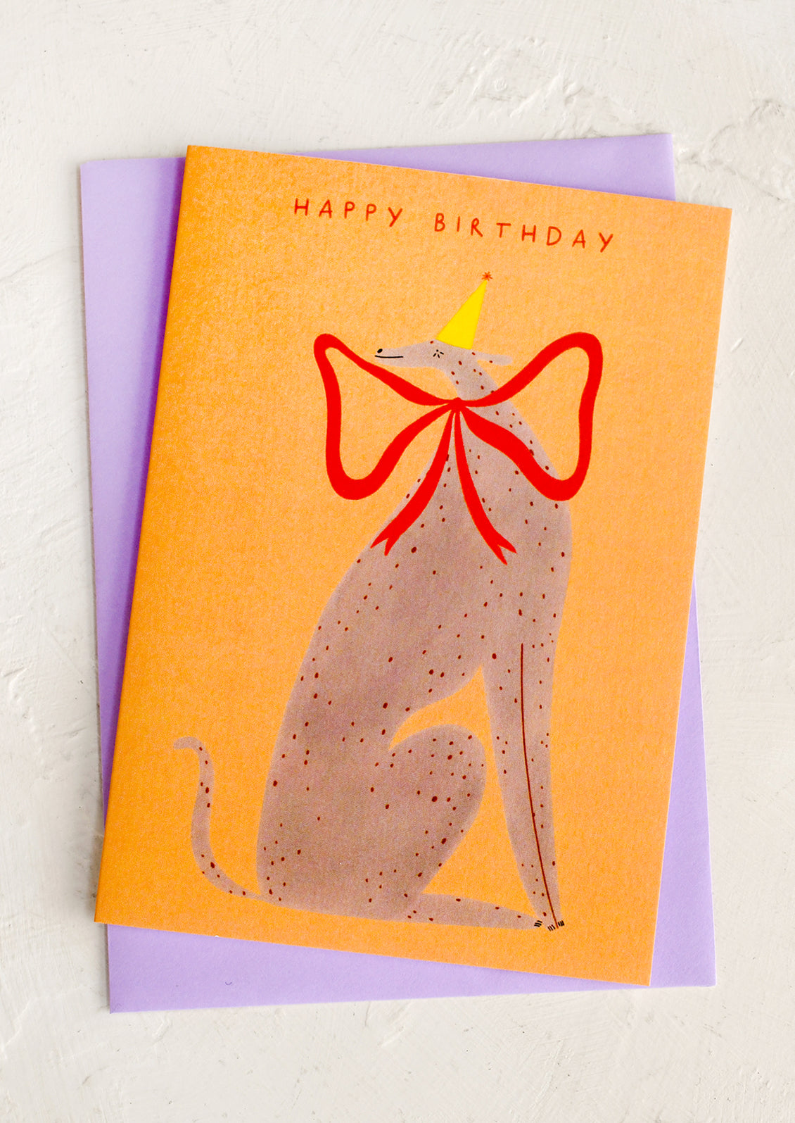Birthday card with a dog wearing a red bow and yellow party hat on an orange background.