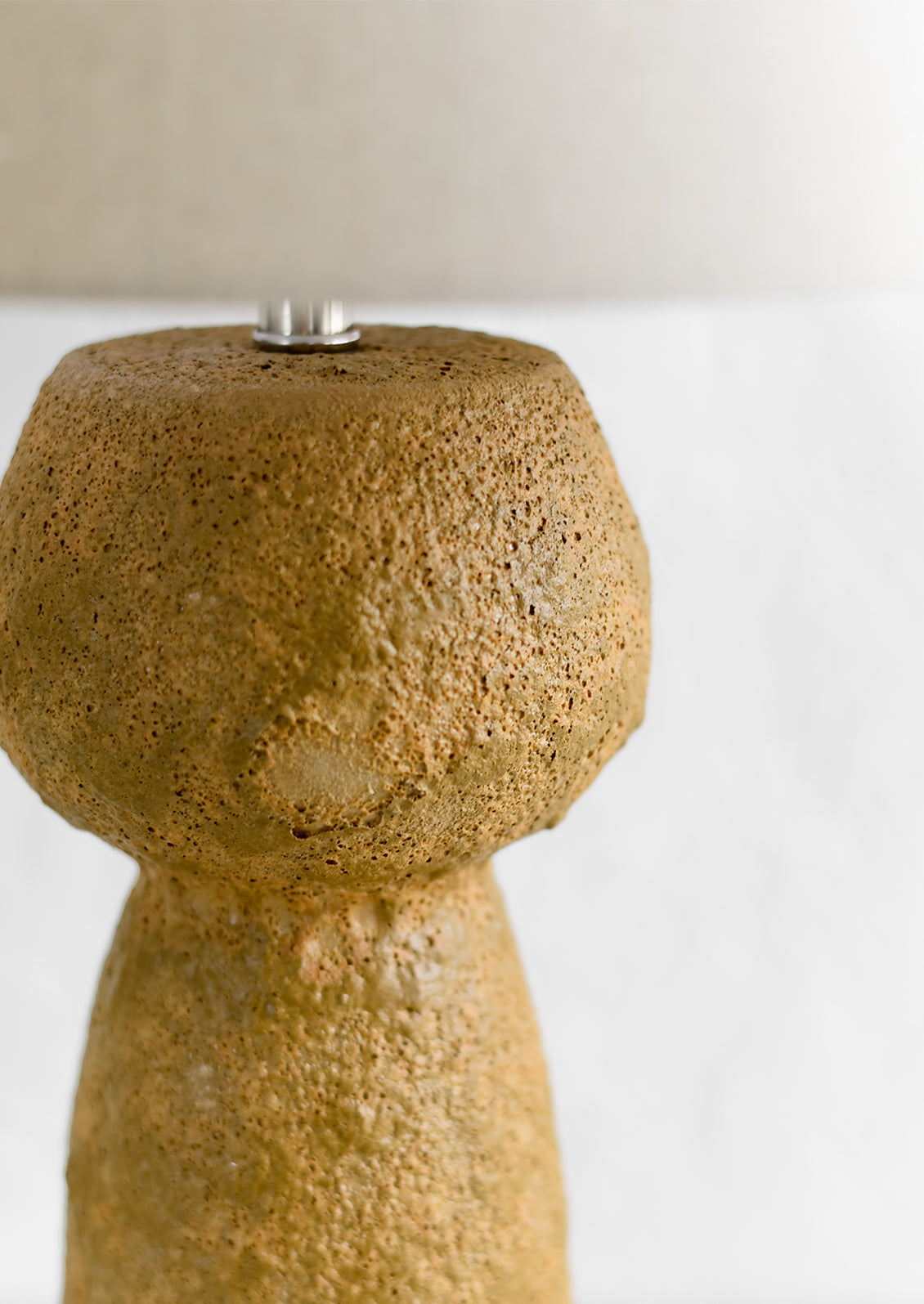 A textured brown stoneware table lamp.