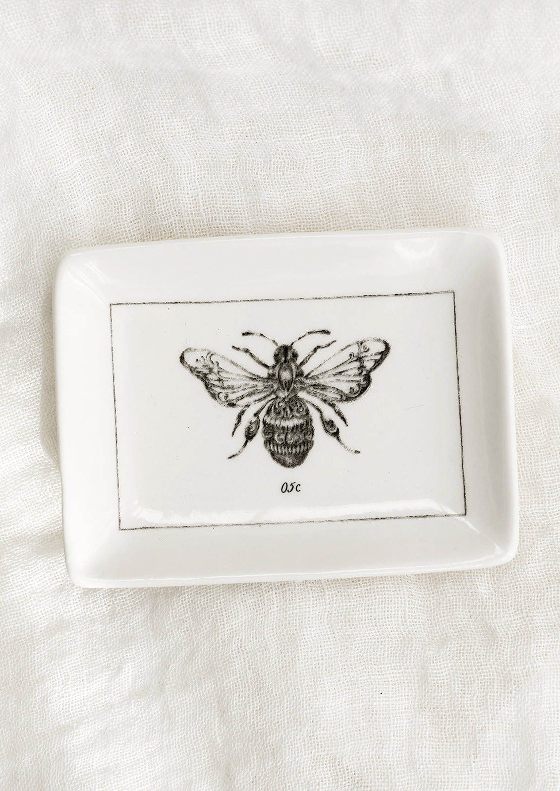 A black and white trinket dish with bee.