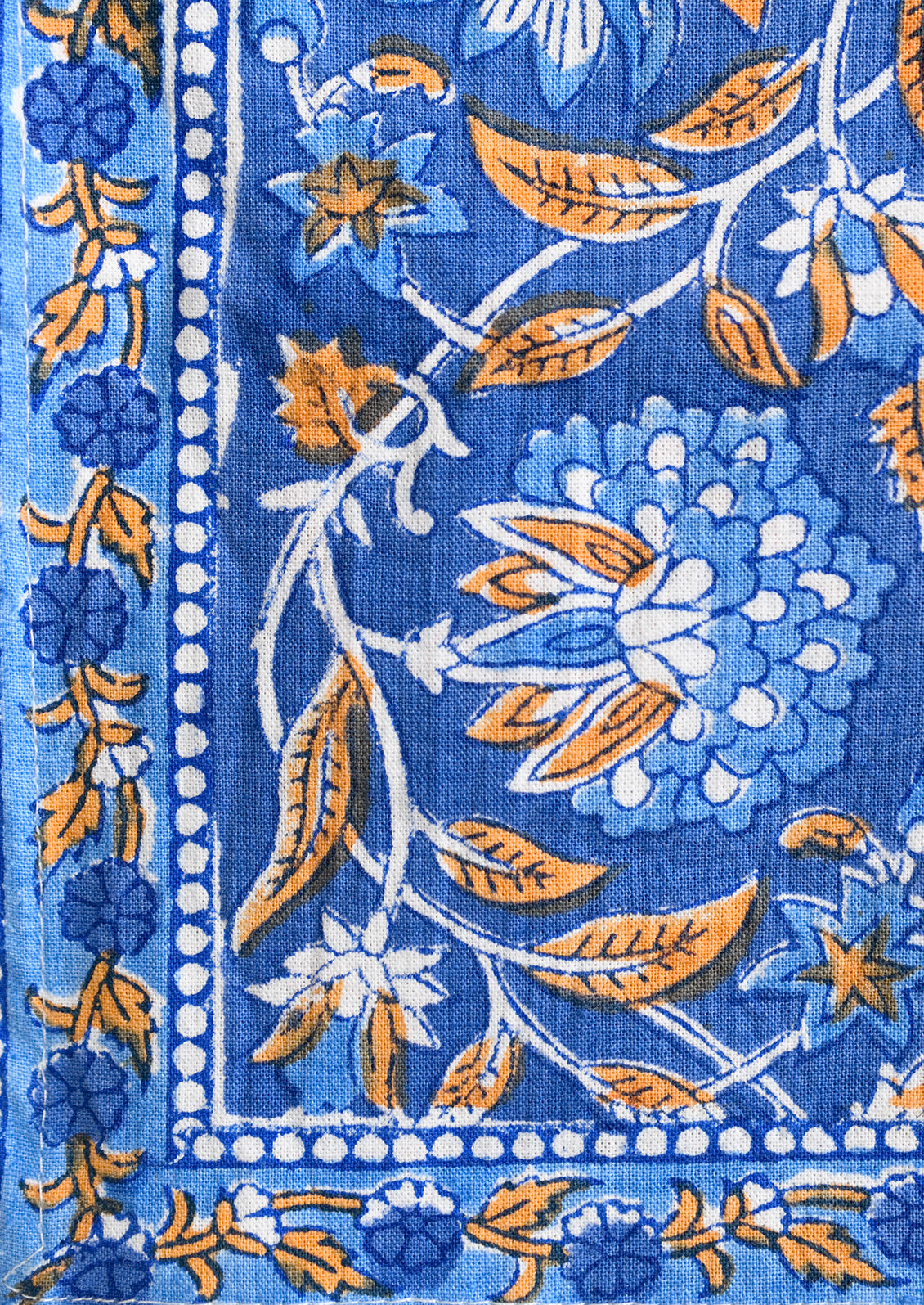 A pair of block print napkins in blue and orange floral.