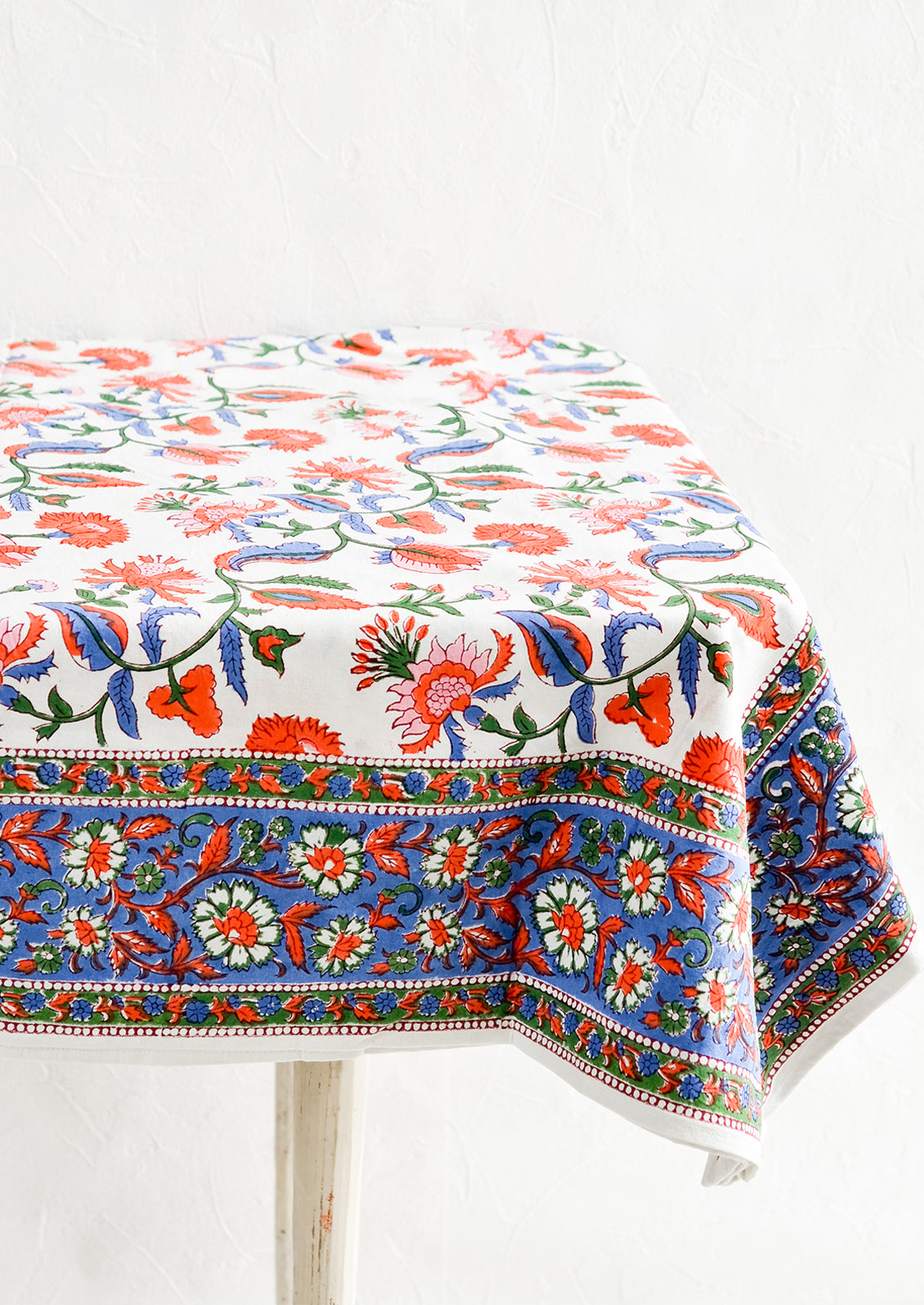 A colorful Indian floral block print tablecloth on a table.