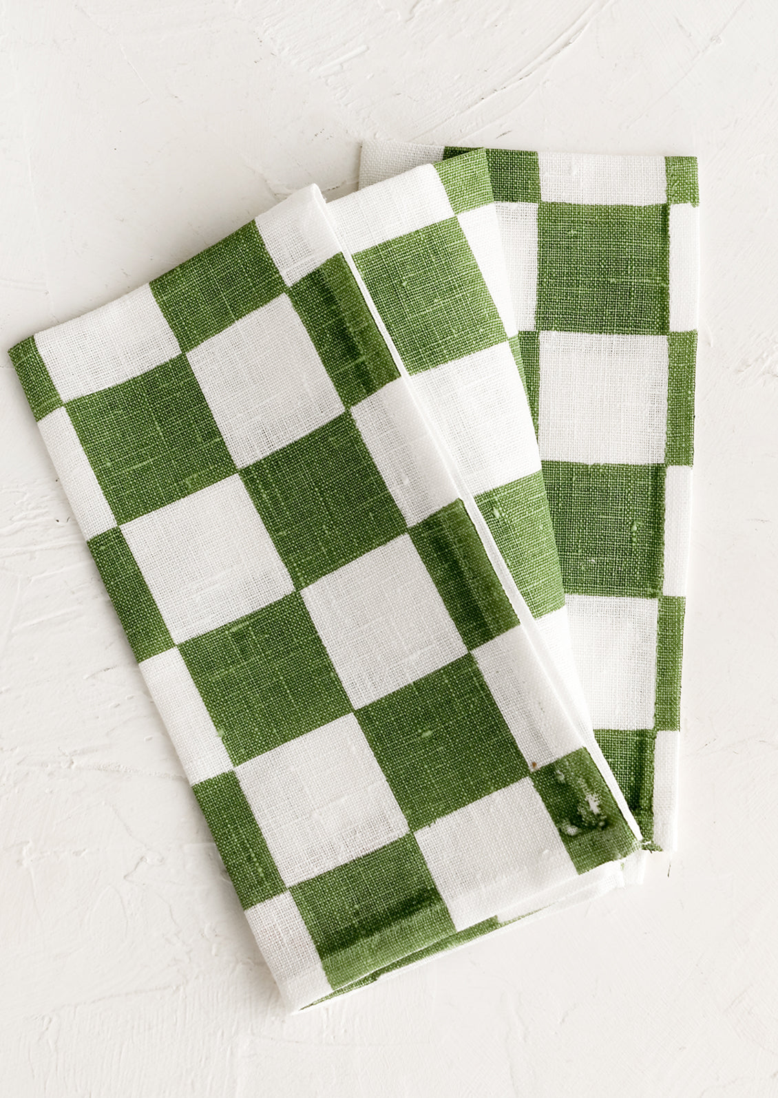 A checkered linen napkin in green and white.