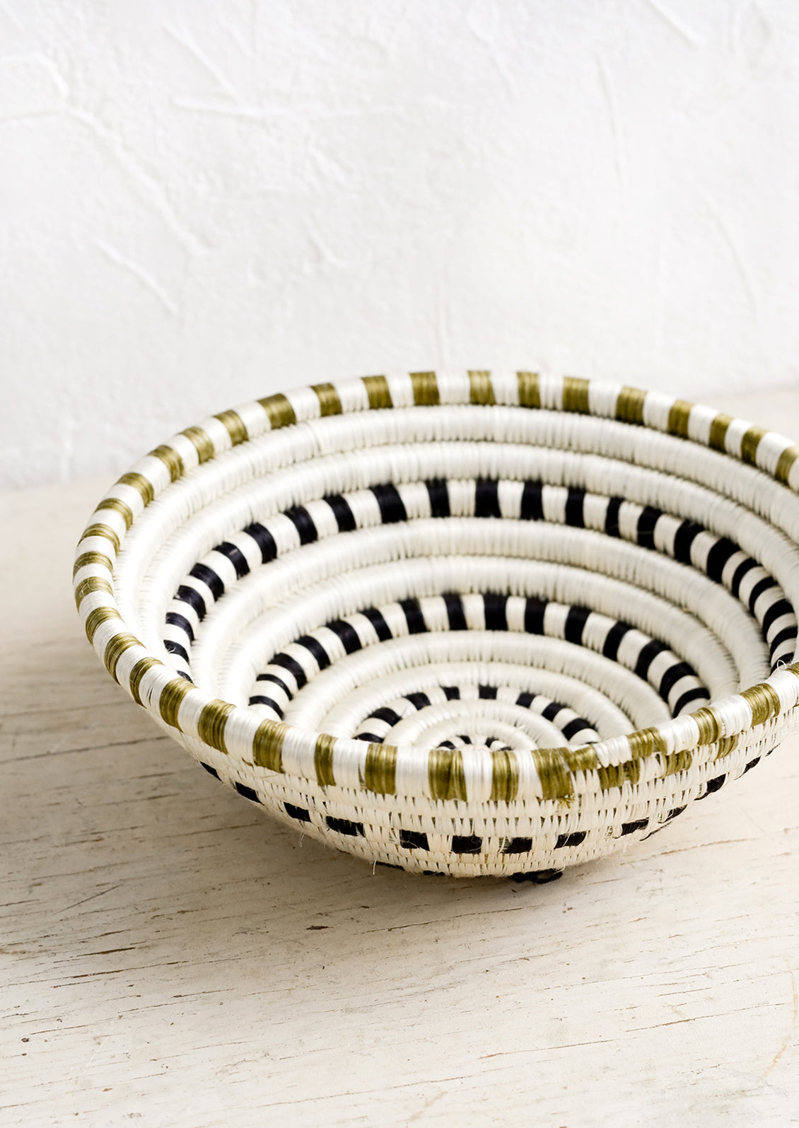 A sweetgrass basket in black and white dash pattern.