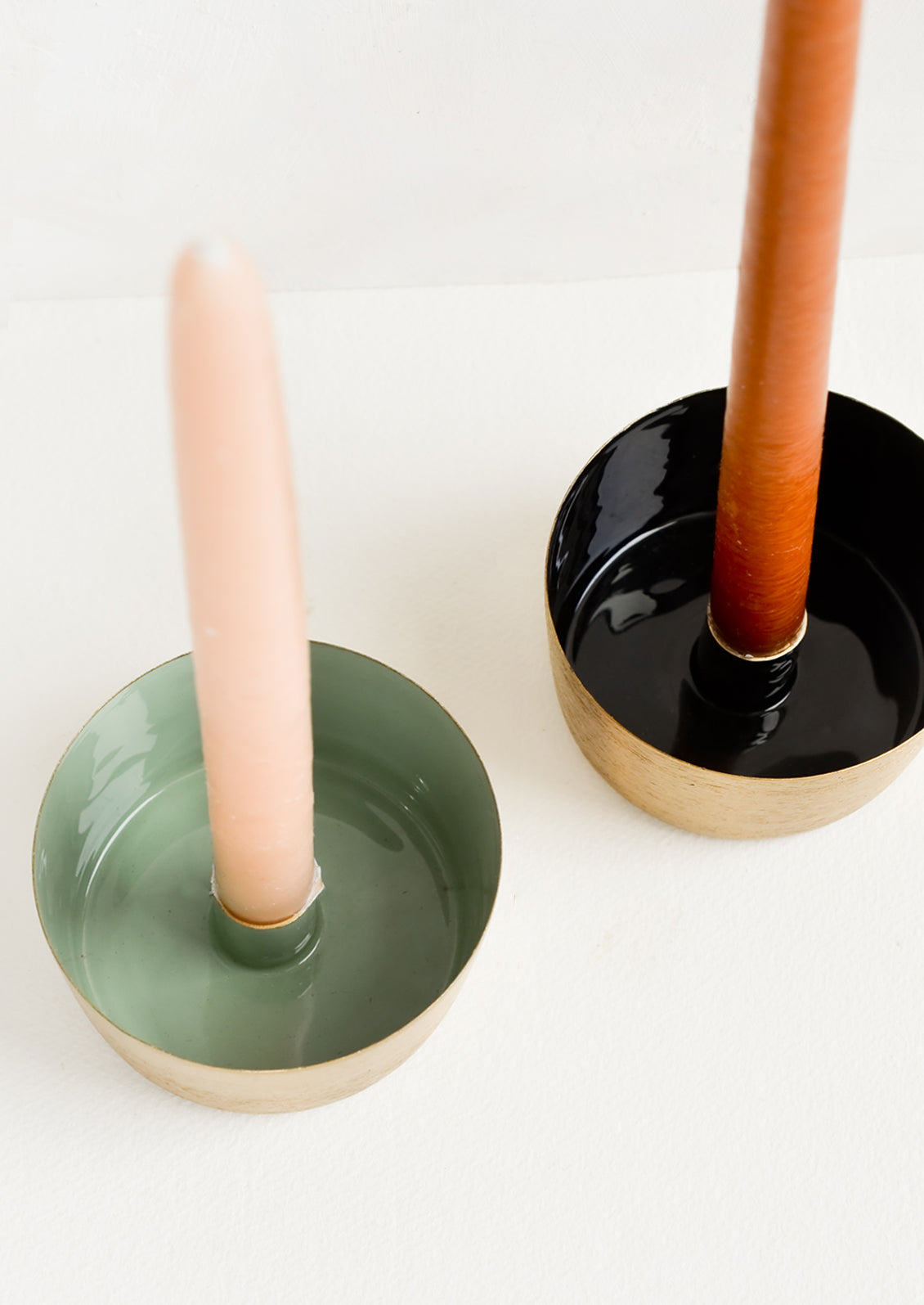 Enamel taper candle holders in green and black with colored tapers.