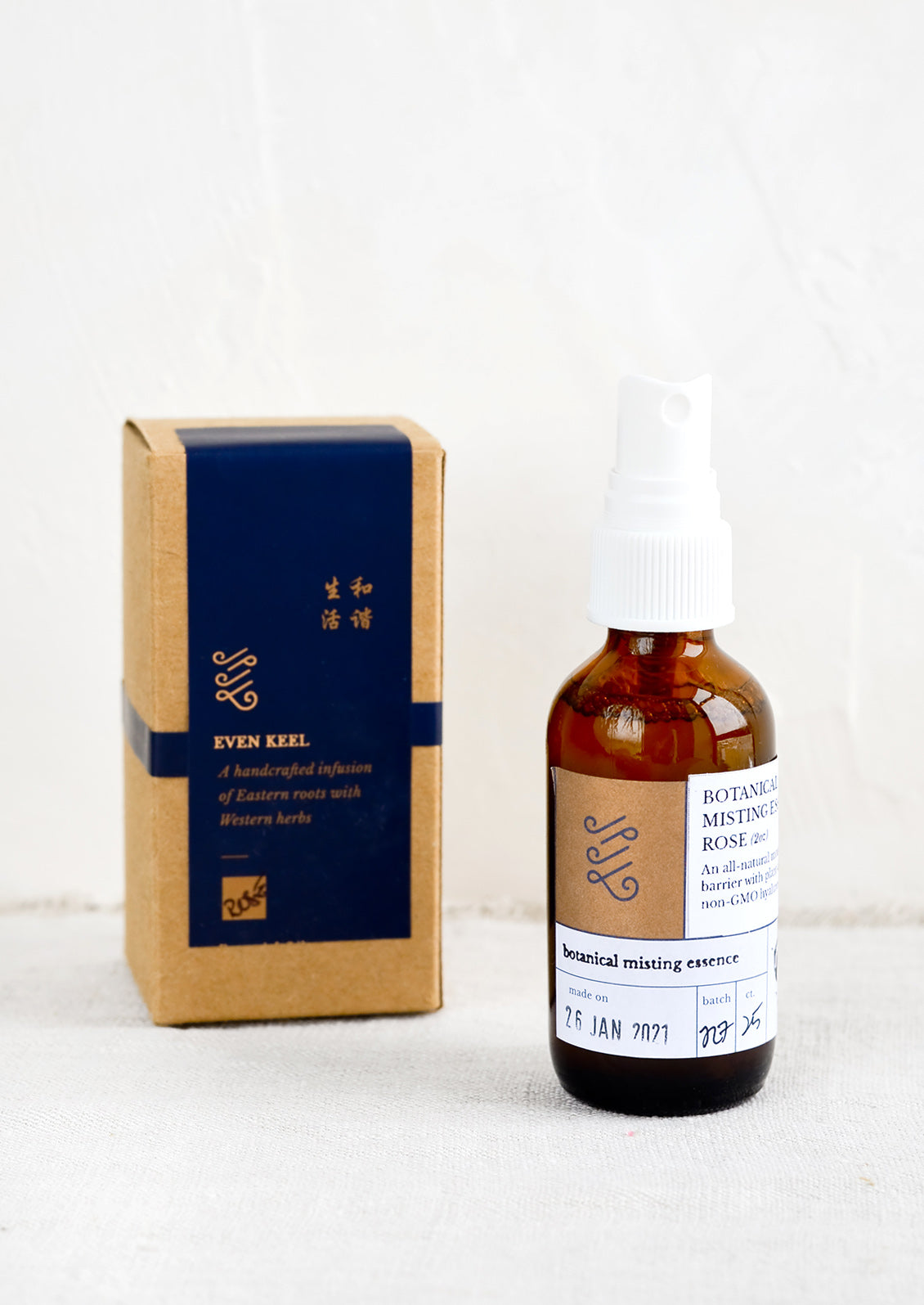 An amber glass spray bottle next to a labeled box.